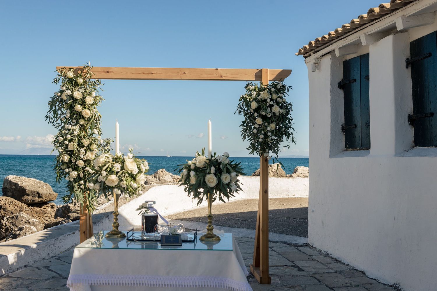 White Mediterranean style buildings with terracotta roofs overlooking a coastal view.