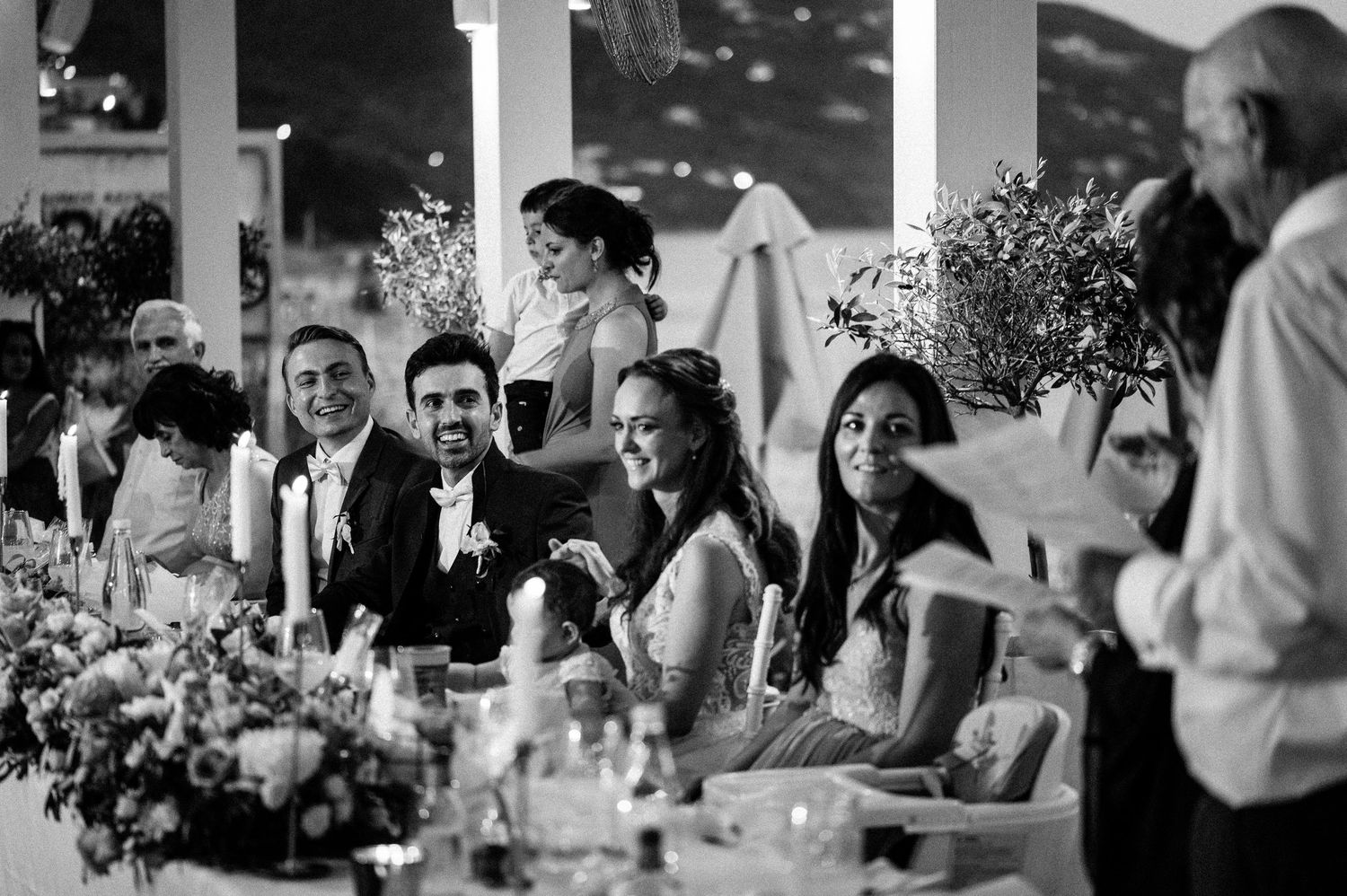 Wedding reception guests enjoying a celebration dinner at elegantly decorated tables.