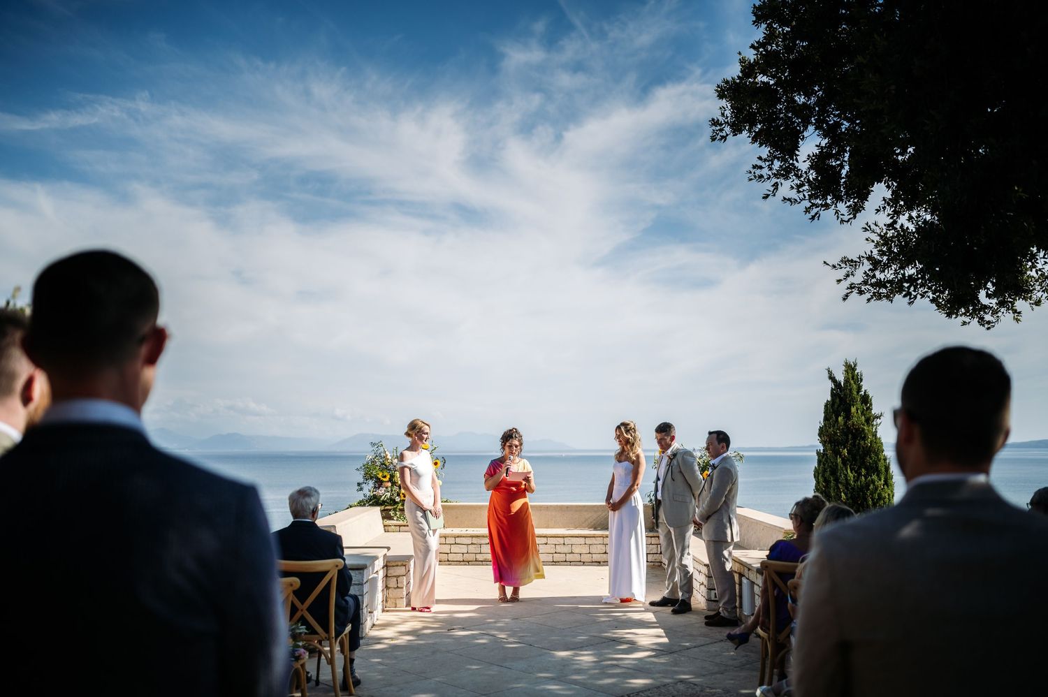 Scenic oceanfront wedding ceremony setup with blue skies and natural landscape.