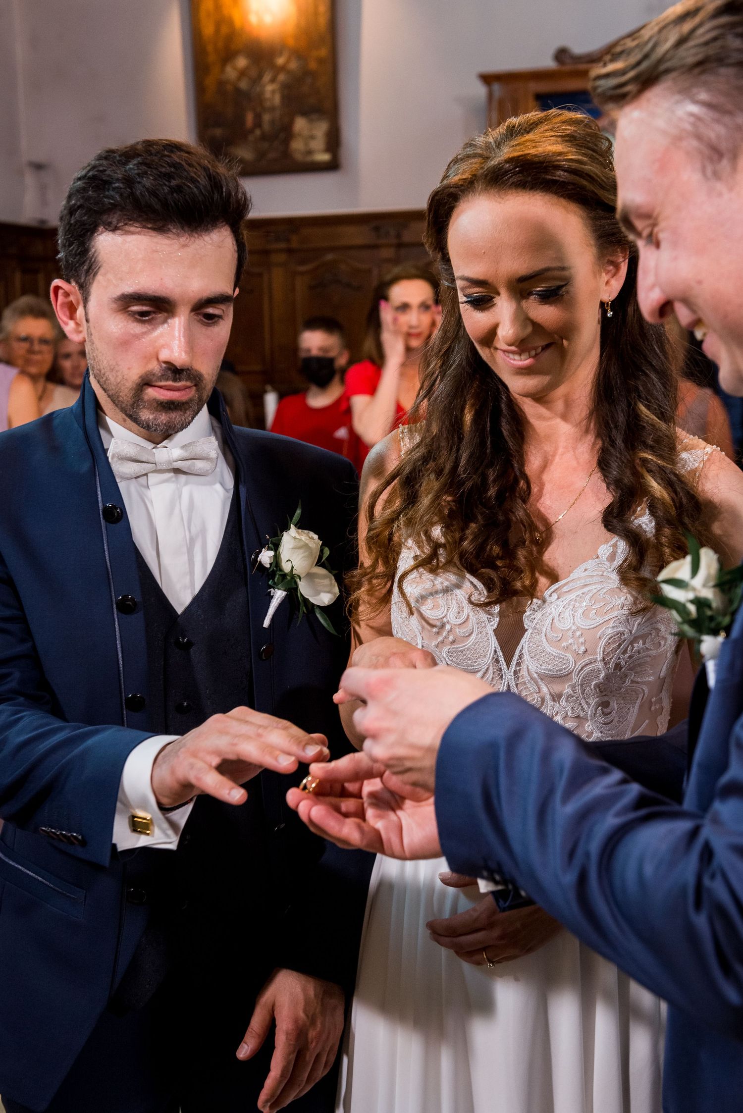 A couple exchanges rings during an intimate wedding ceremony indoors.
