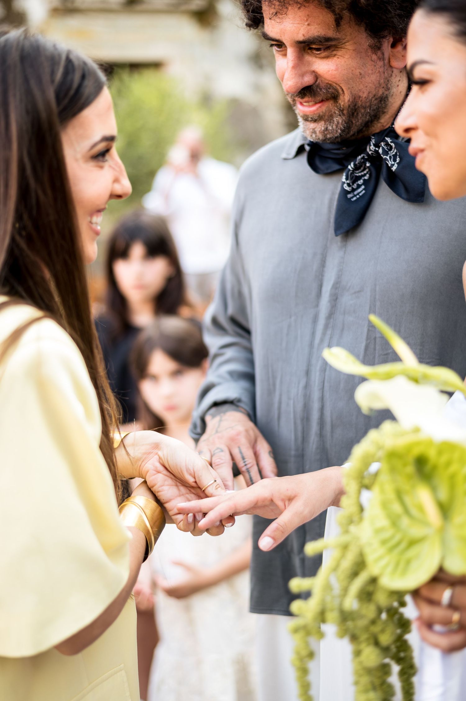 Wedding guests share joyful moments at an outdoor celebration with soft lighting and yellow accents.