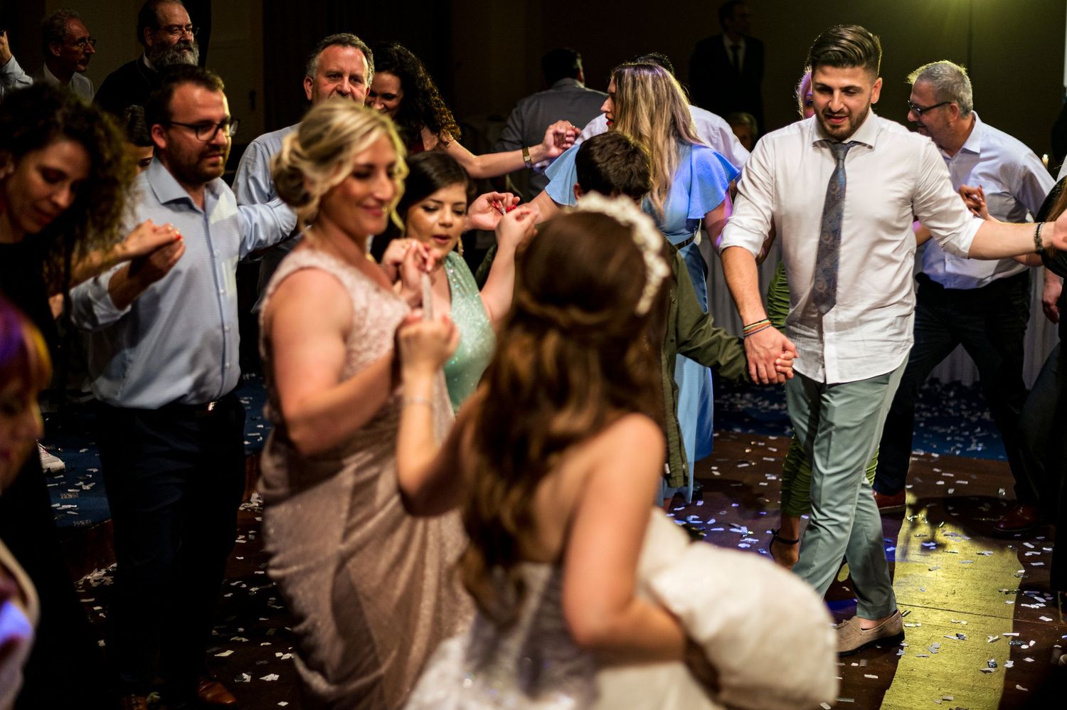 Wedding reception dance floor filled with guests celebrating and dancing together.
