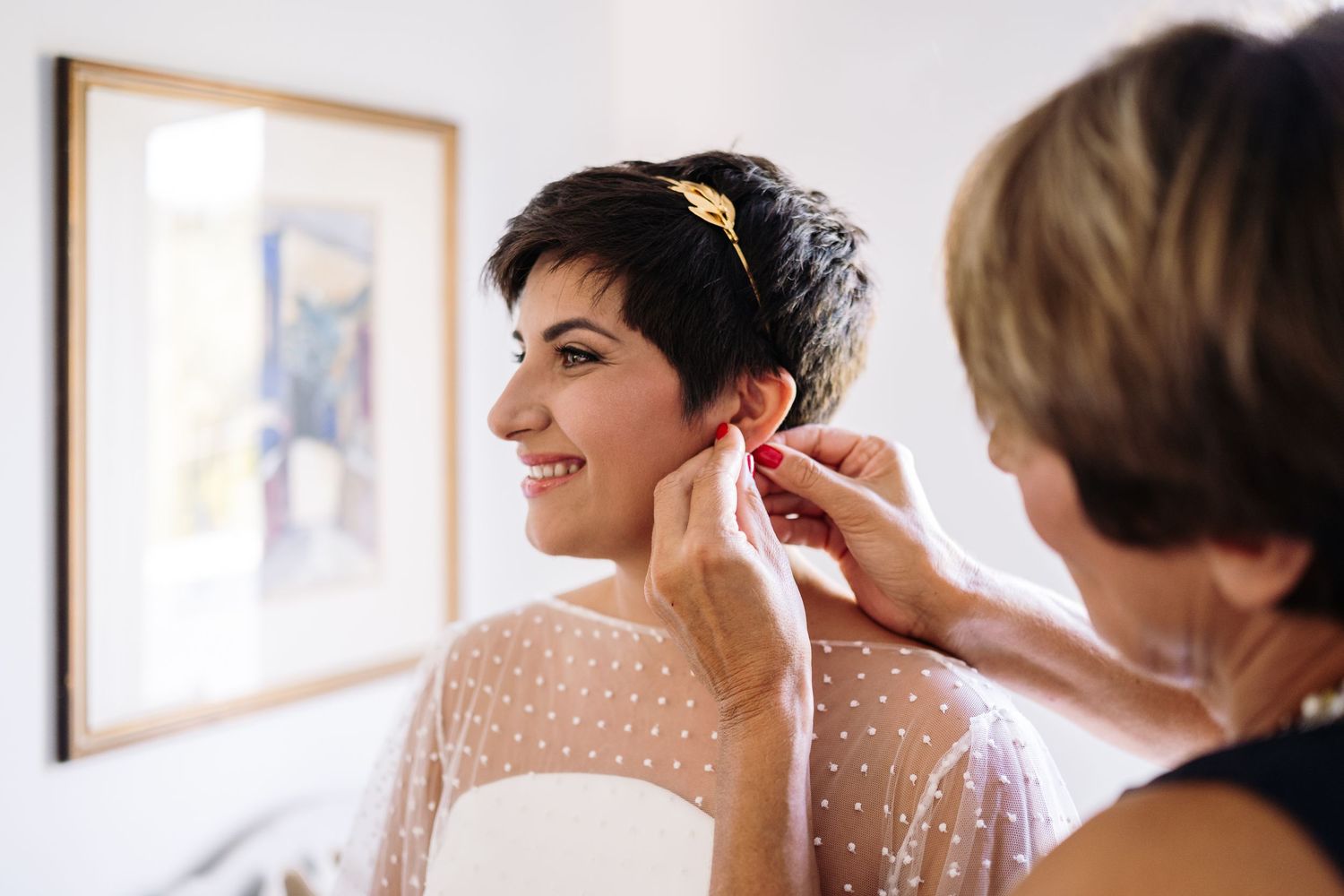 Wedding preparation scene showing final touches and adjustments in a bright room.