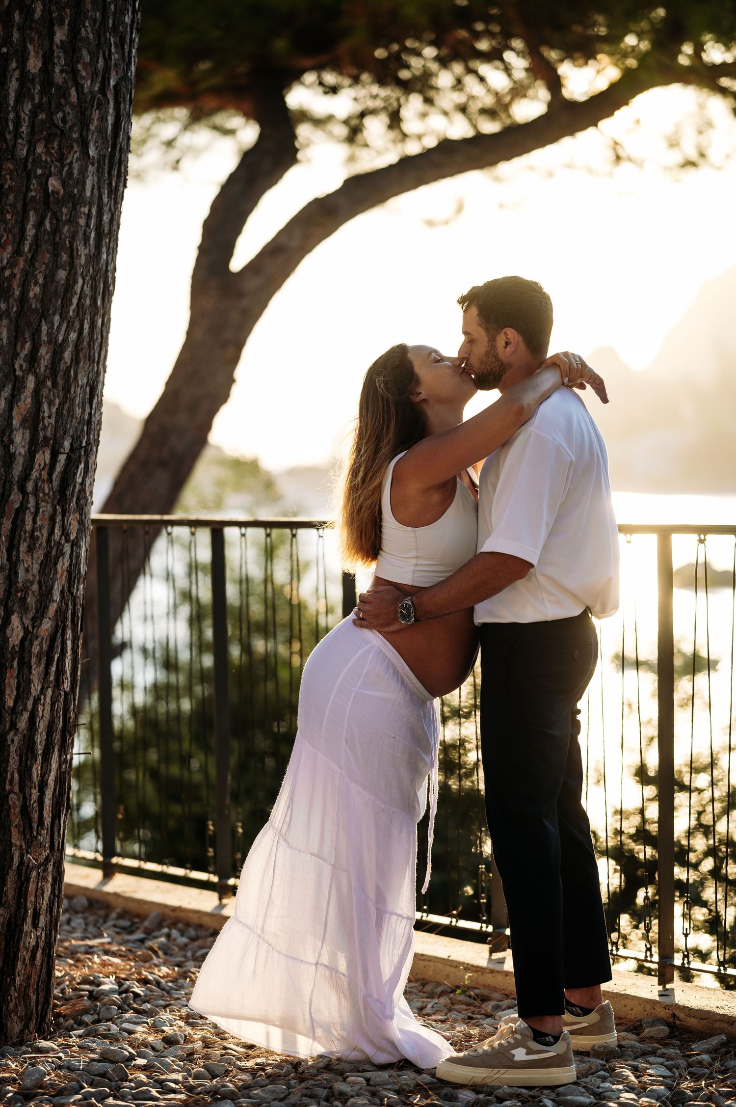 Romantic dance sequence captured under pine trees with ocean vista at golden hour.