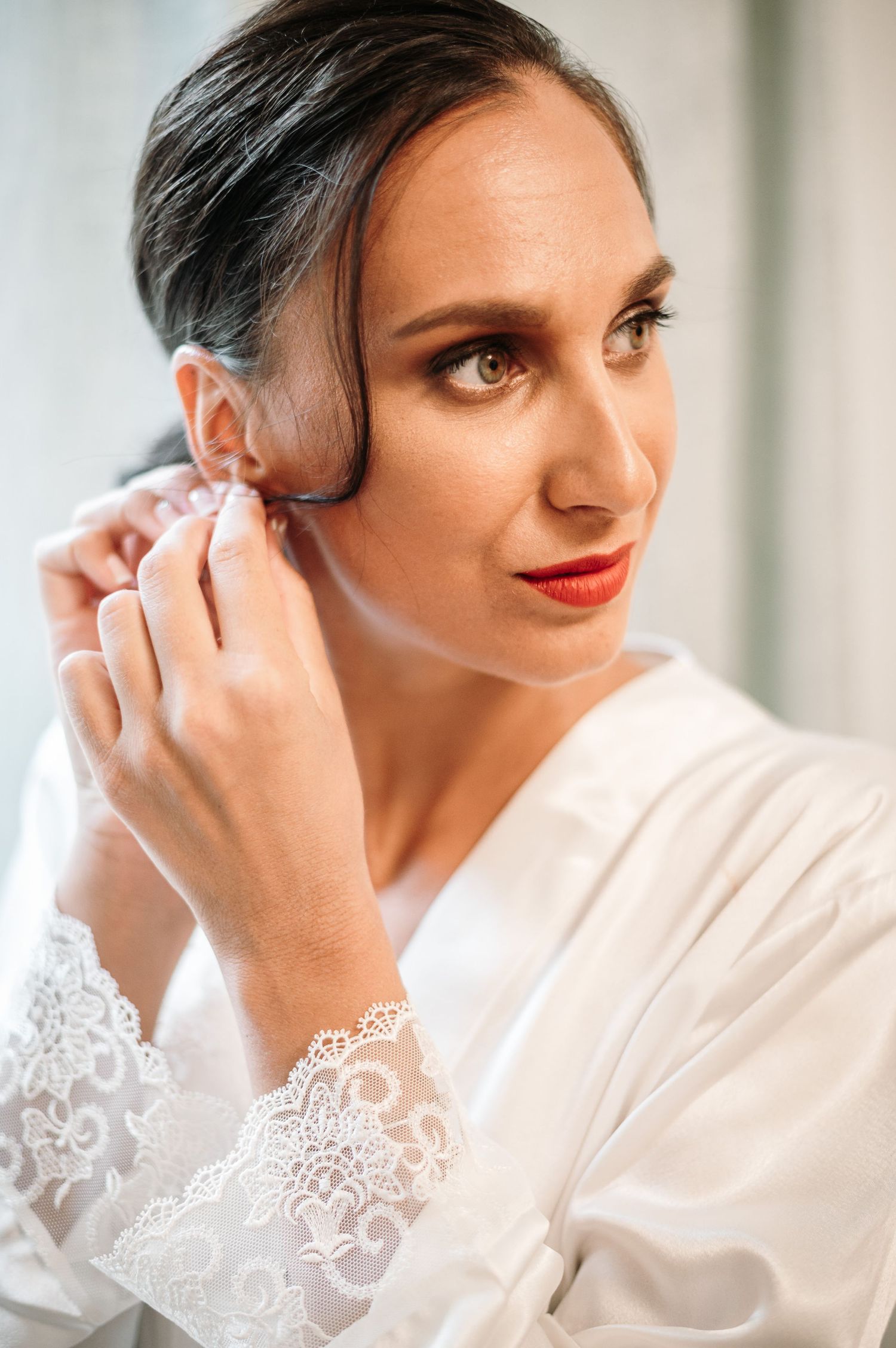 Close-up shots of bridal preparation showing lace robe details and elegant makeup.