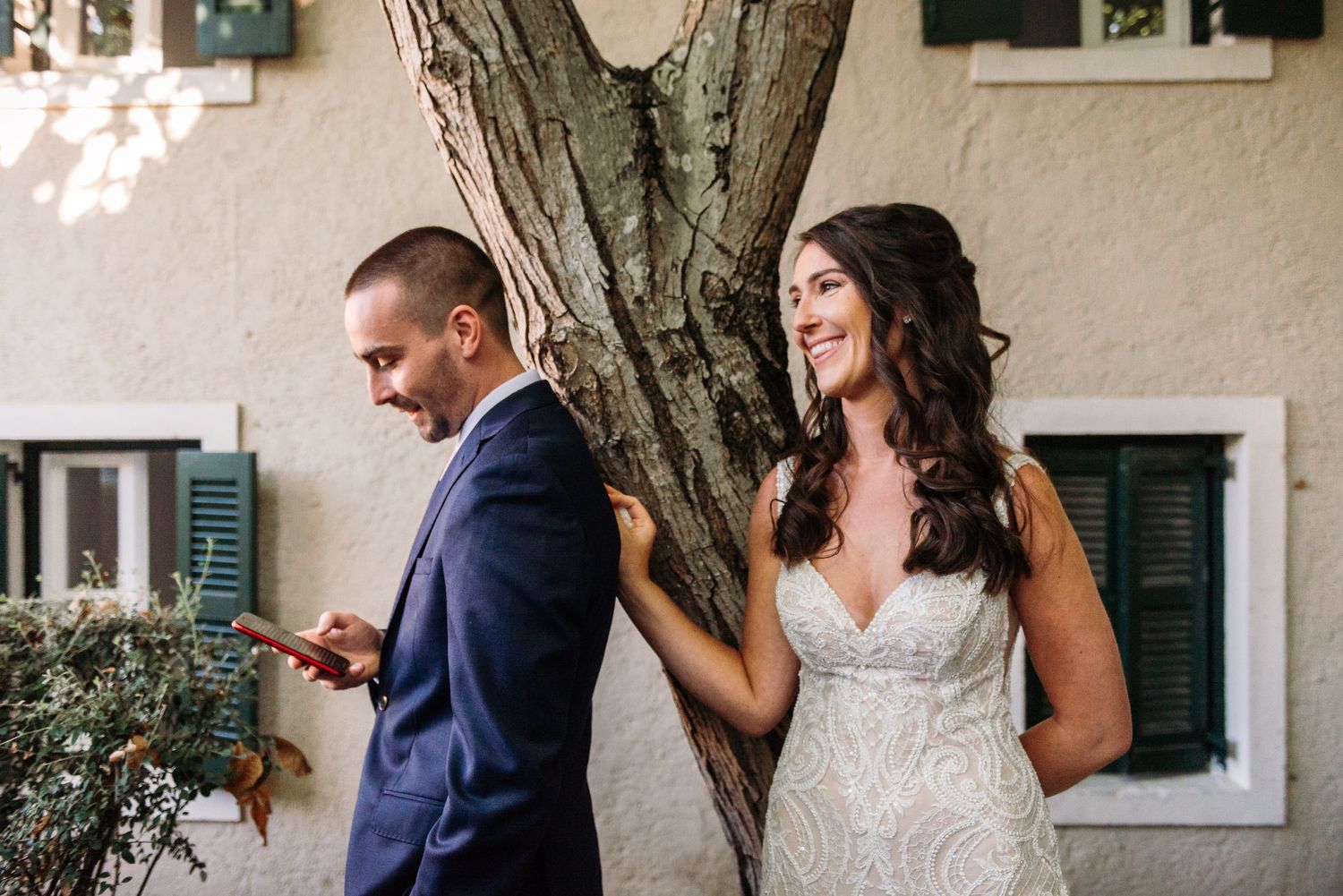 A couple shares intimate moments against a rustic white wall backdrop.