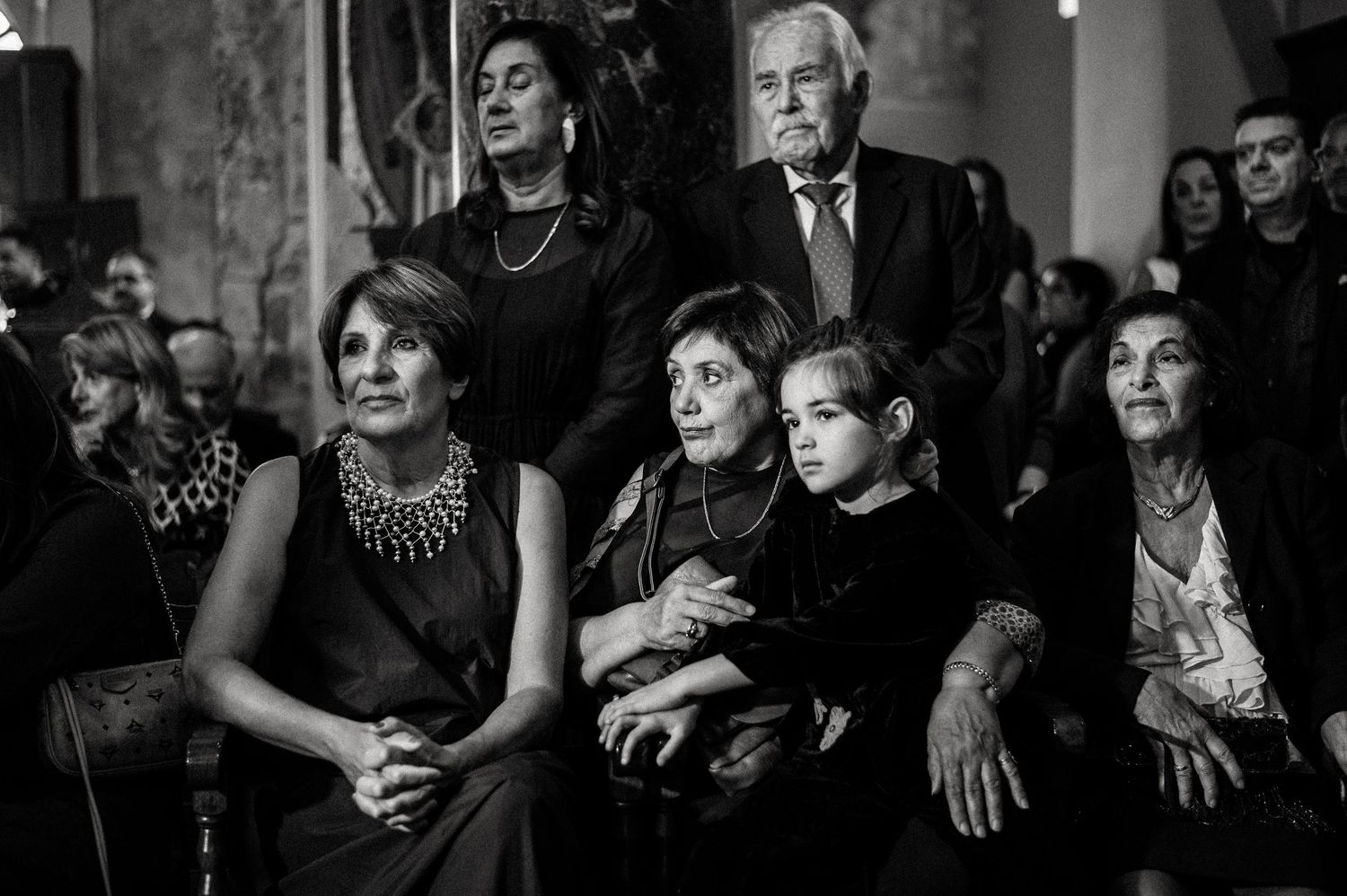 Black and white photo of wedding guests reacting emotionally during ceremony.