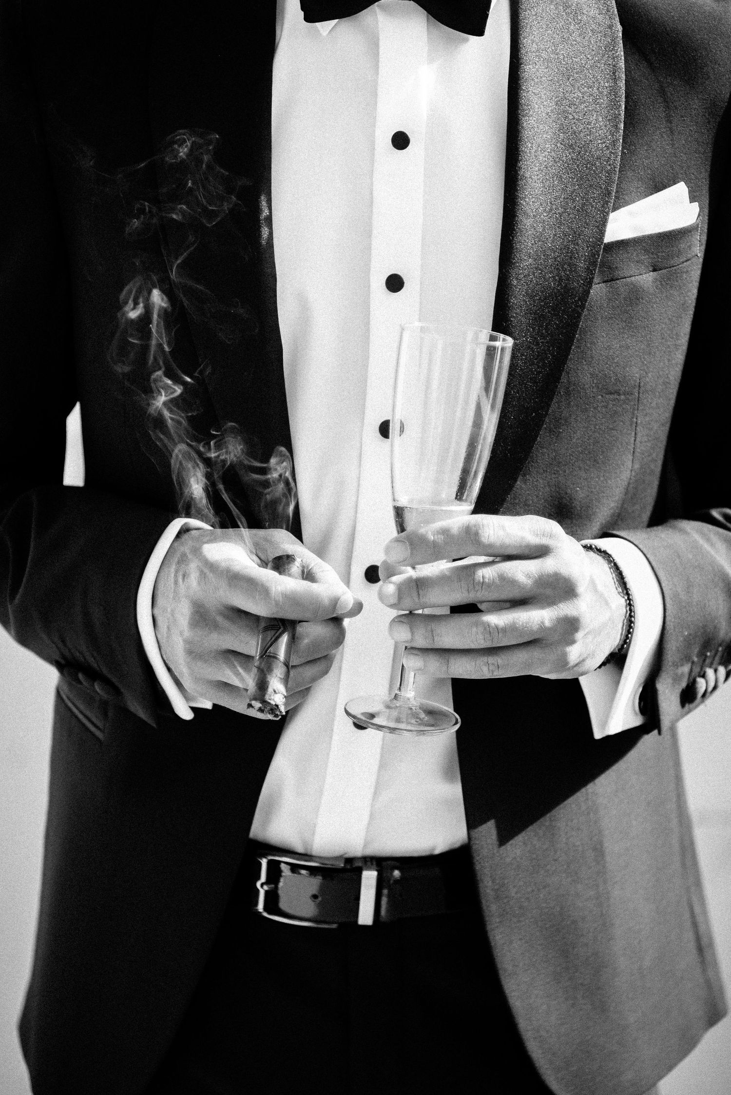 Black and white image of formal wear with bow tie and champagne glasses.