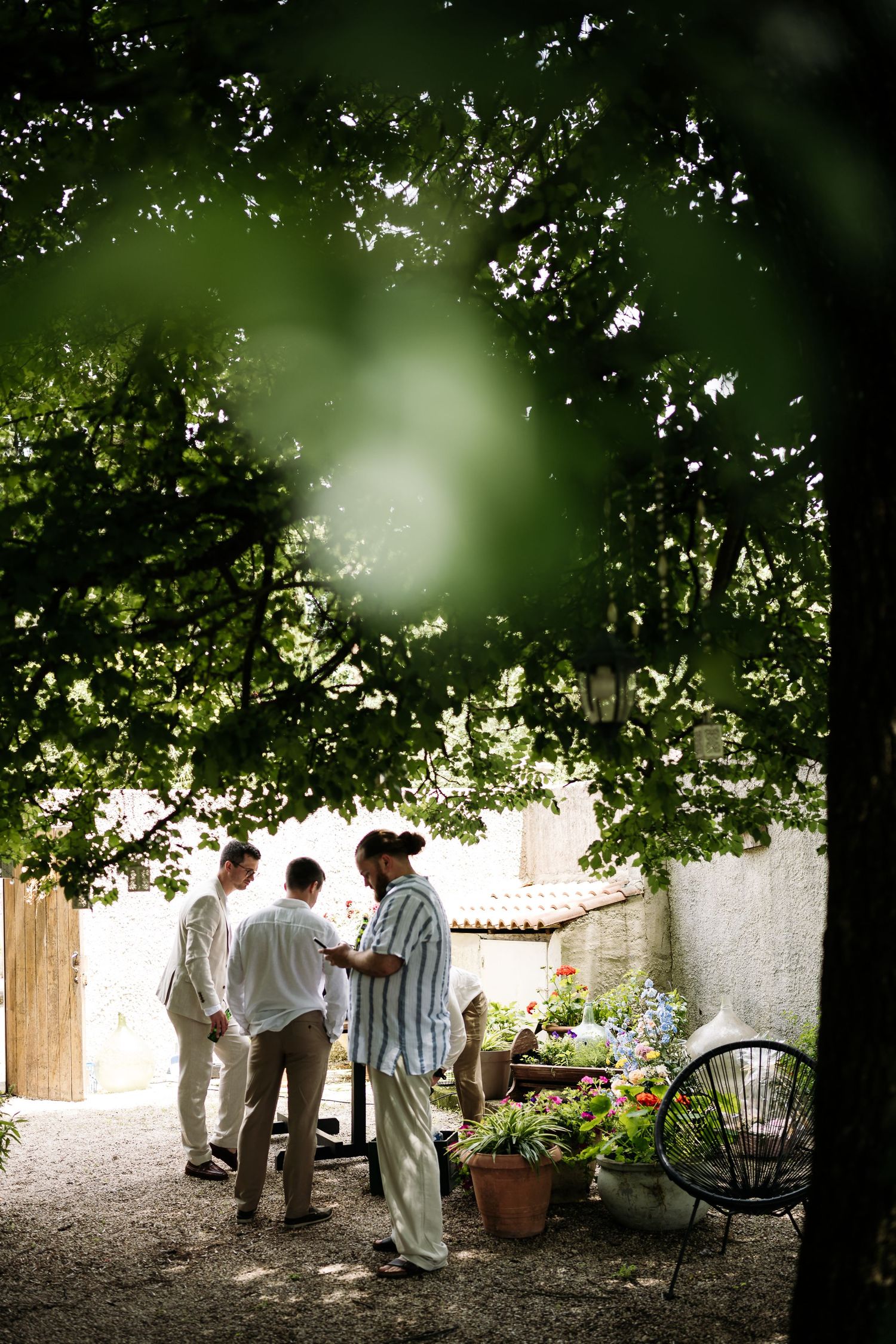 Group gathers under shaded trees for an intimate outdoor gathering.