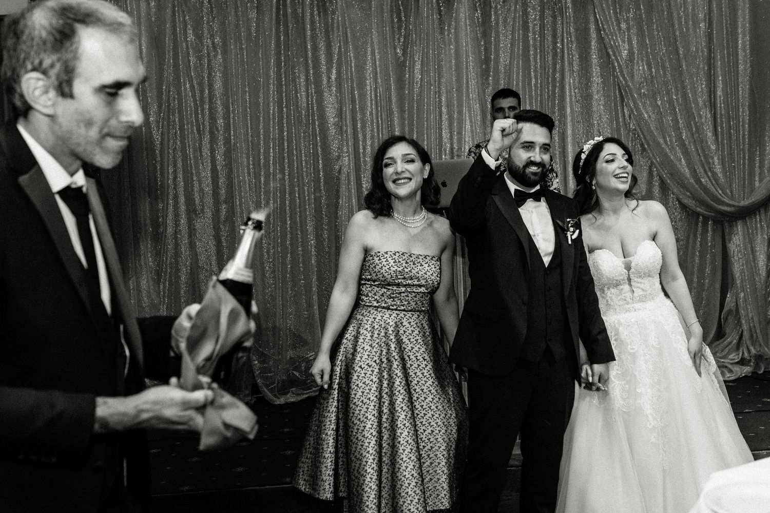 Wedding reception guests dancing and celebrating in a dimly lit venue with elegant decor.