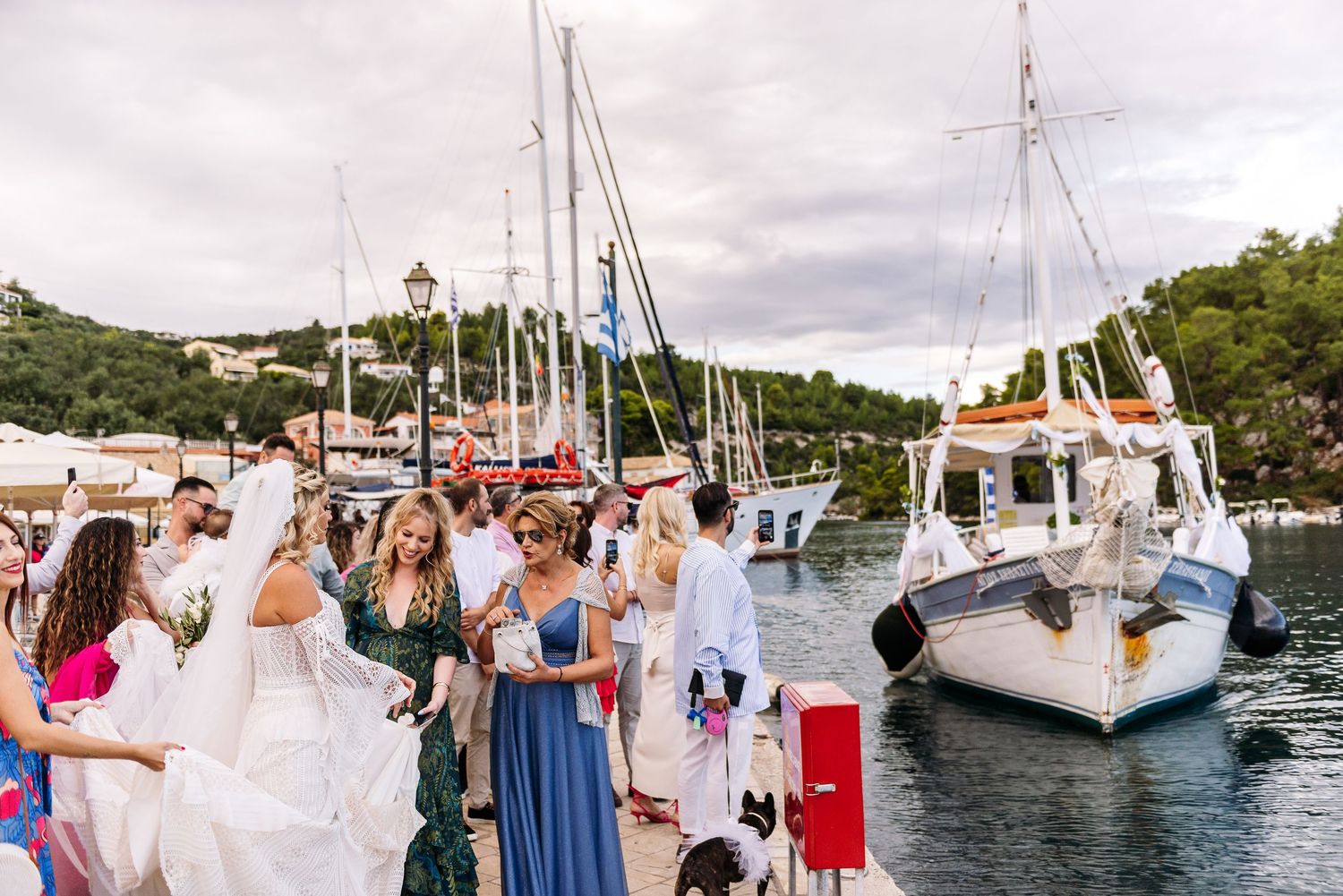 Wedding celebration on a marina dock with sailboats in the background.