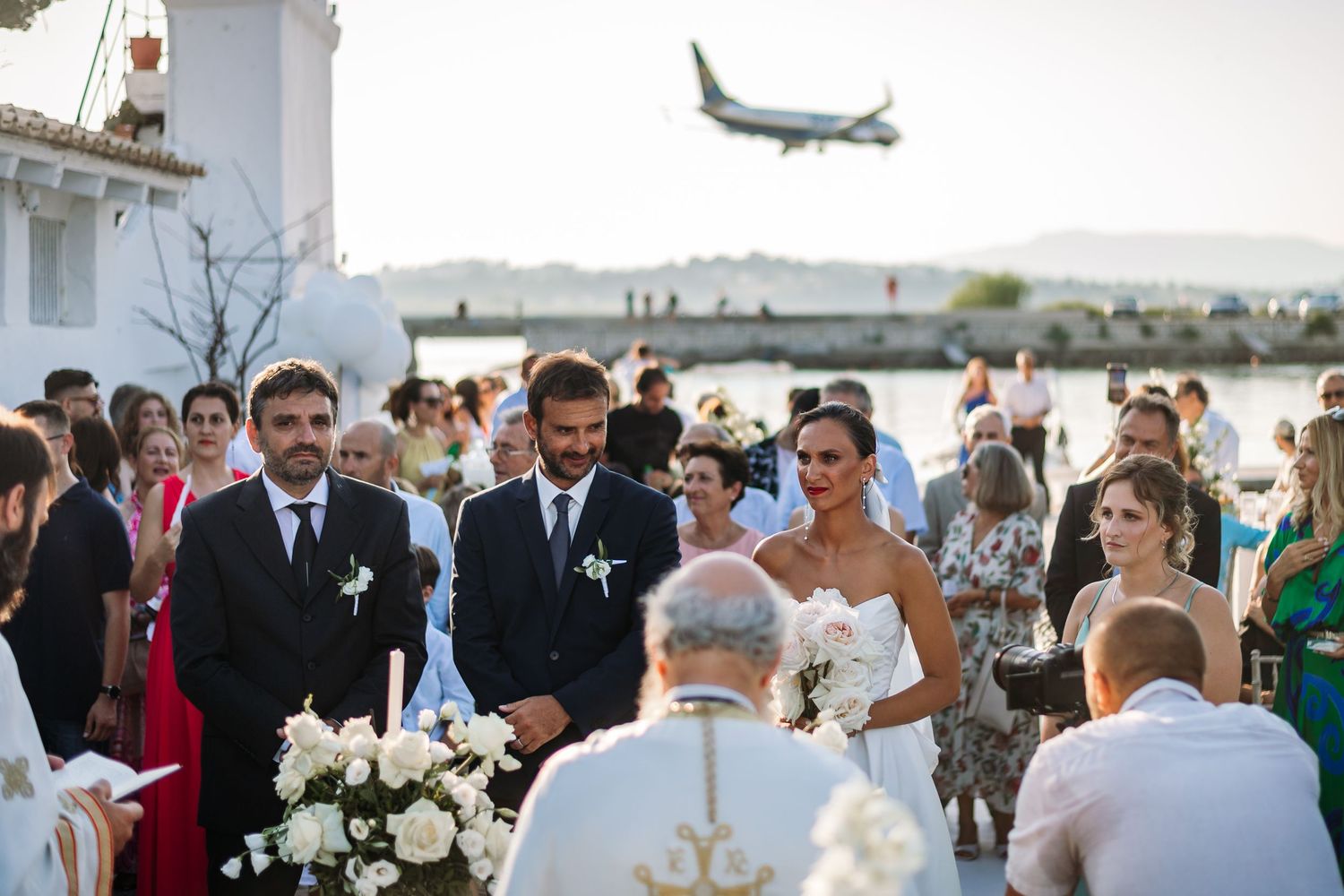 Wedding guests gather outdoors for a celebration with elegant floral arrangements and decor.