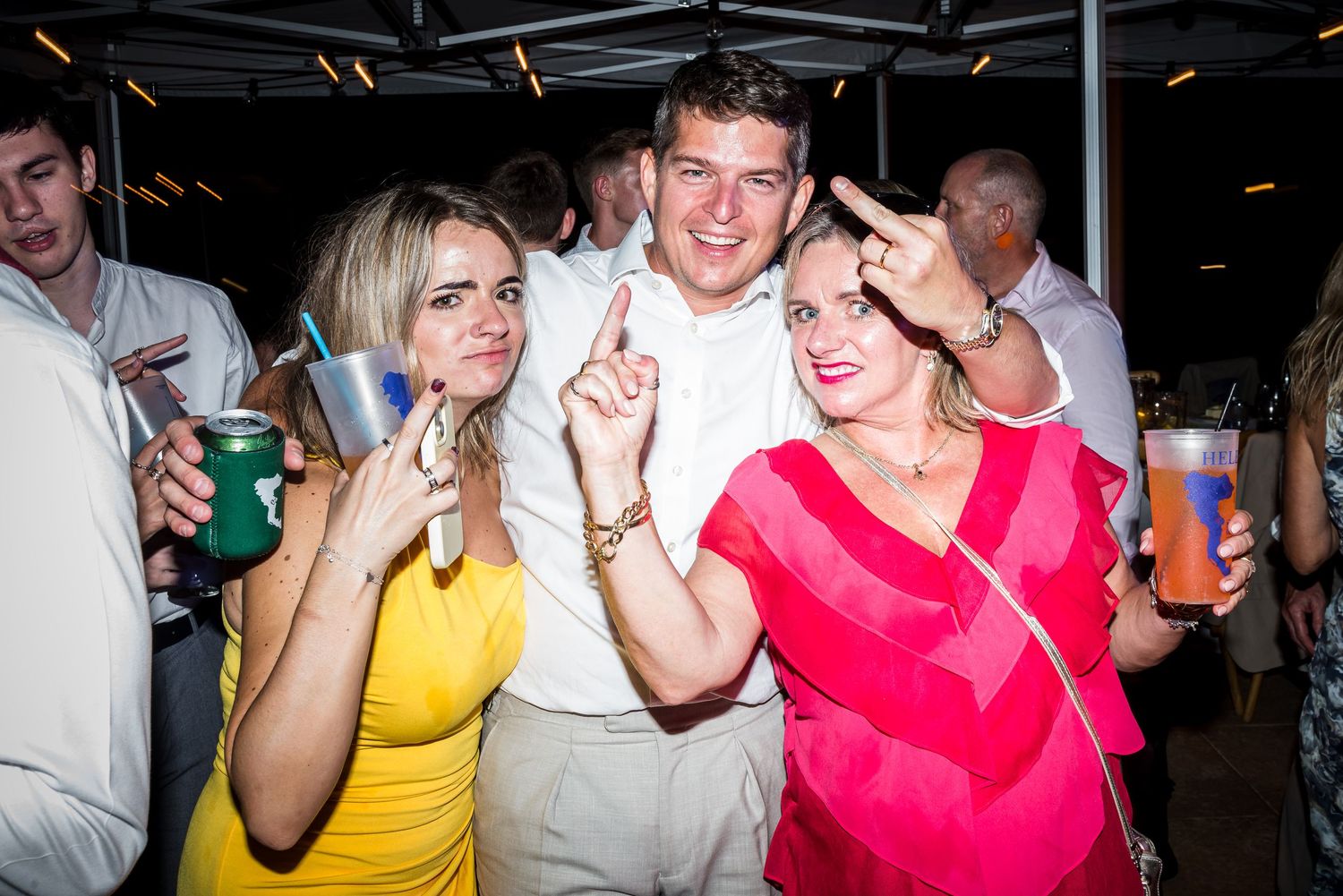 Lively dance party scene with colorful lighting and people dancing in a nightclub atmosphere.