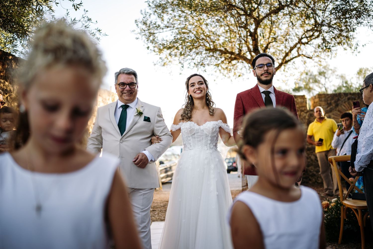 Candid moments of wedding guests mingling and dancing during an outdoor celebration at dusk.