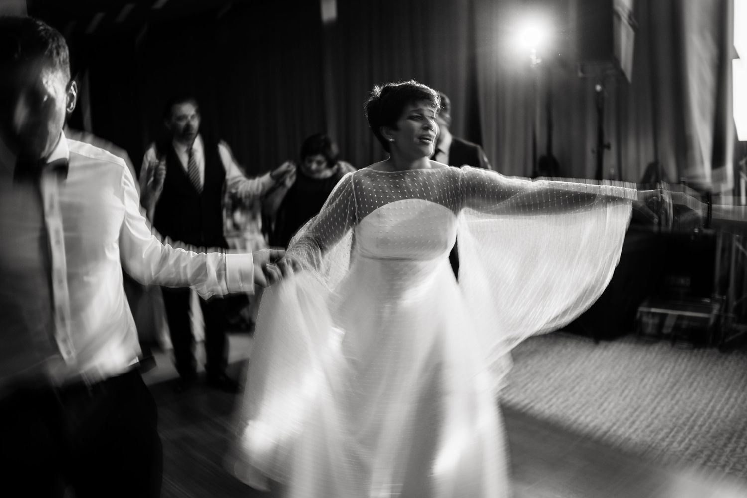 Artistic black and white shot of wedding dancers in motion on ballroom floor.