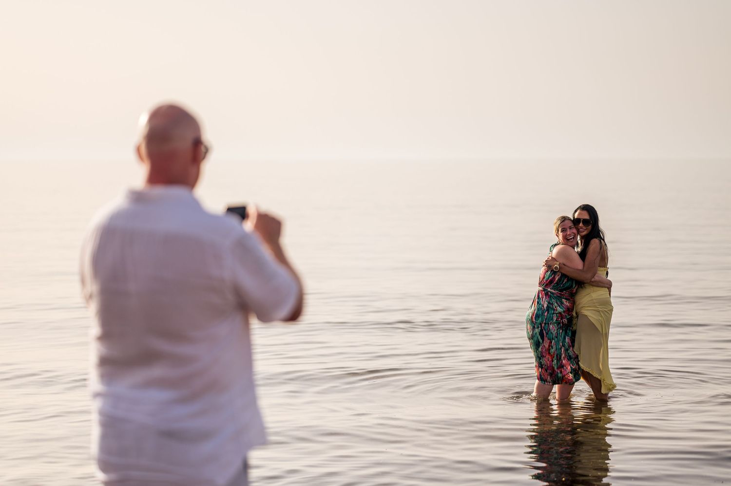 Romantic sunset photoshoot silhouettes against a serene ocean backdrop.