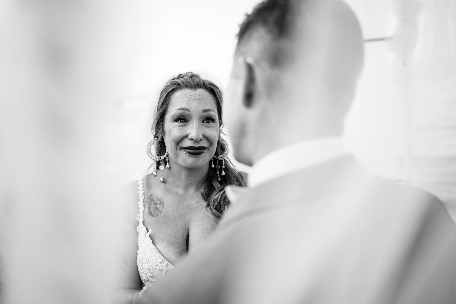 Black and white photo of a couple sharing emotional moments during their wedding ceremony.