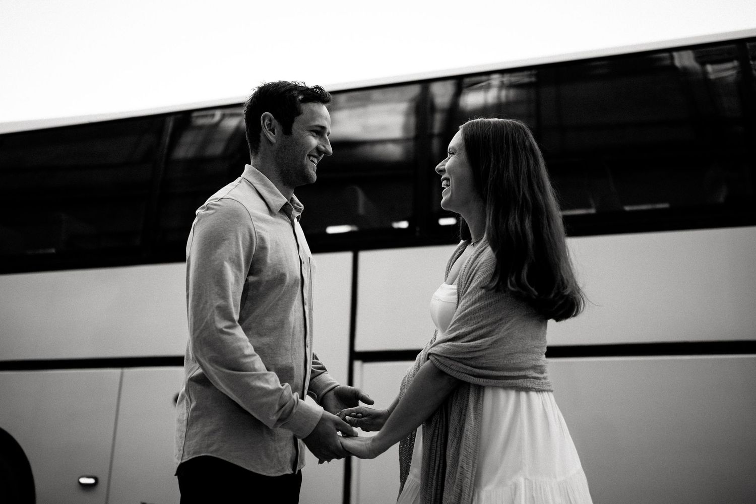 Black and white image of a couple in conversation against a stark background.