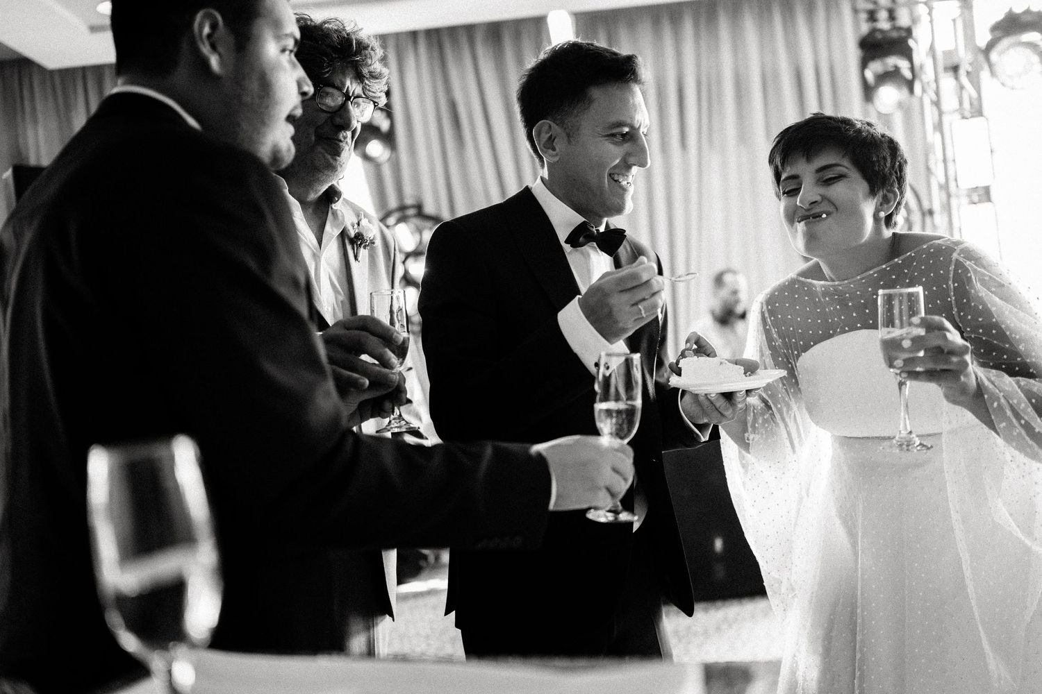 Wedding reception guests enjoying candid moments at an elegant indoor venue.