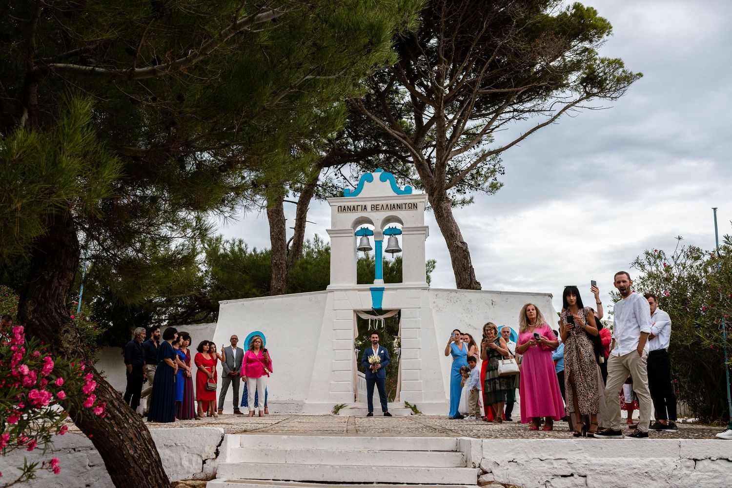 White Mediterranean church with bell tower set against blue sky for destination wedding.
