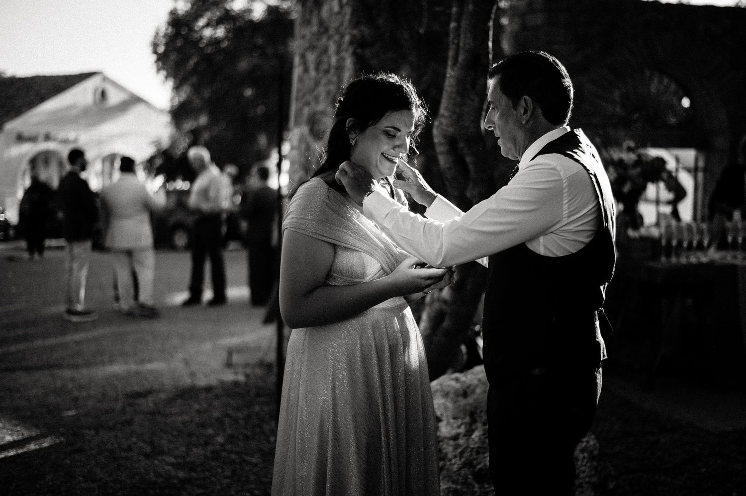 Black and white candid shots of wedding guests dancing and celebrating at an outdoor reception.