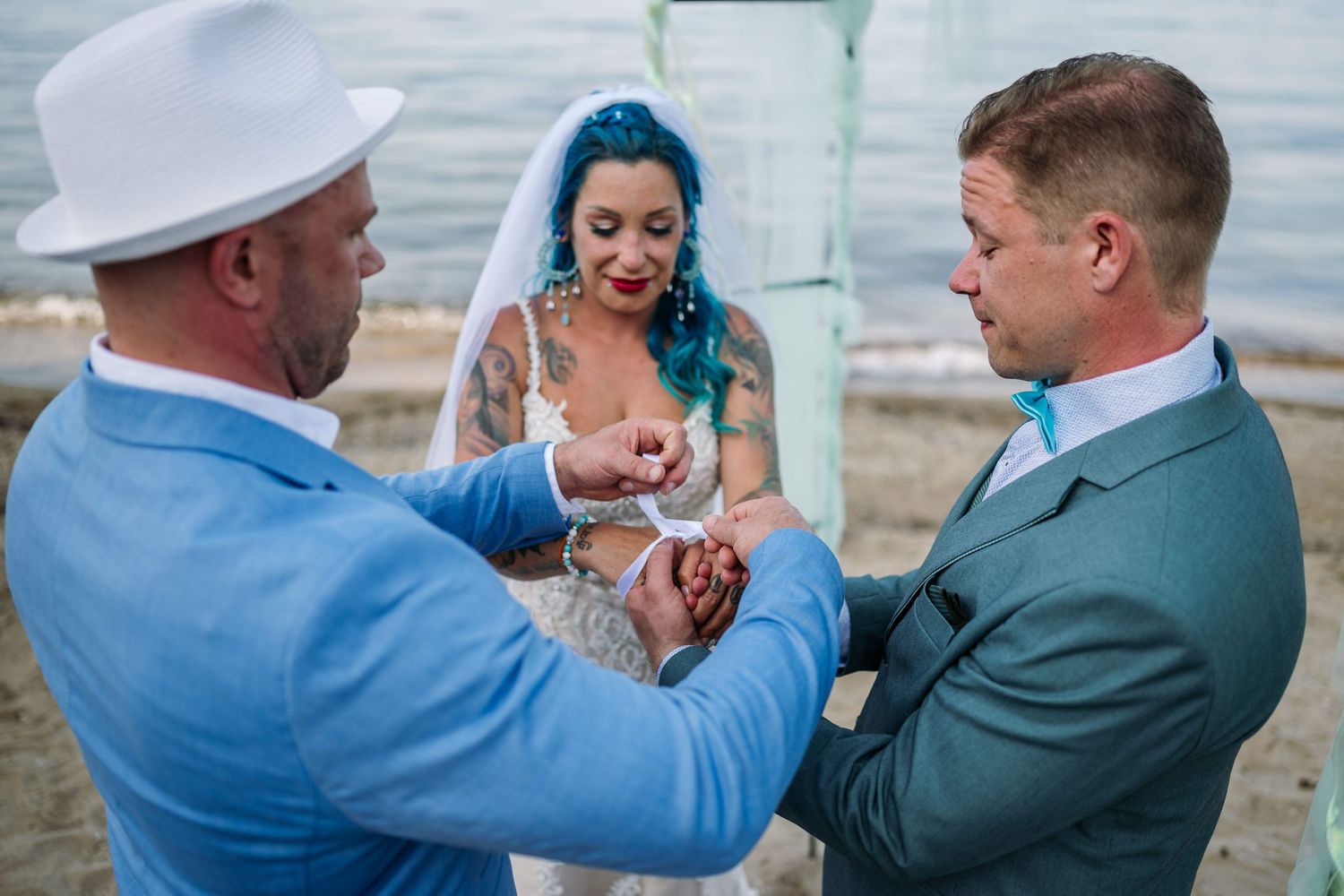 A joyful wedding ceremony moment captured at the beach with guests participating.
