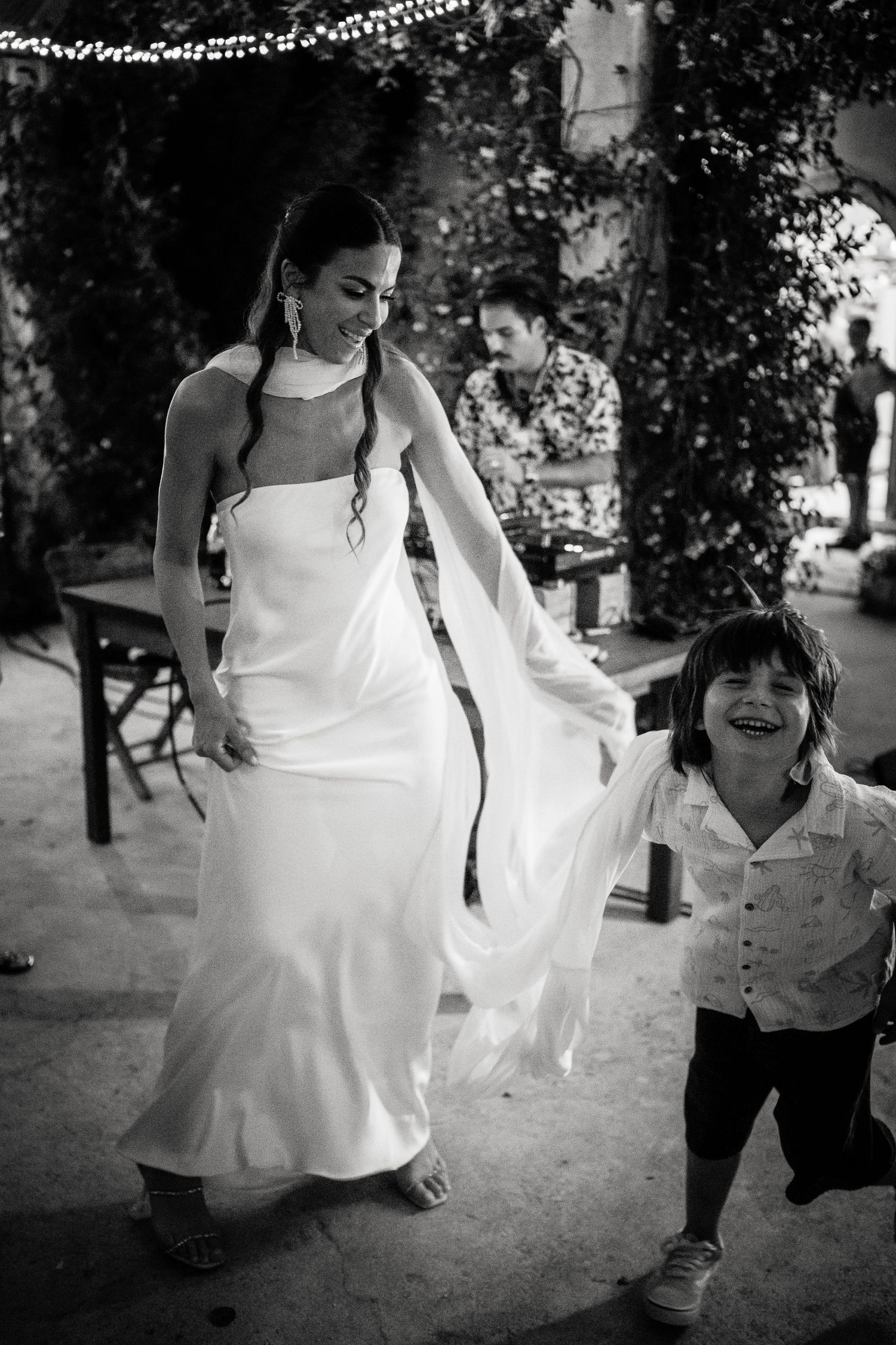Black and white photos capture joyful dancing moments at an outdoor wedding celebration.