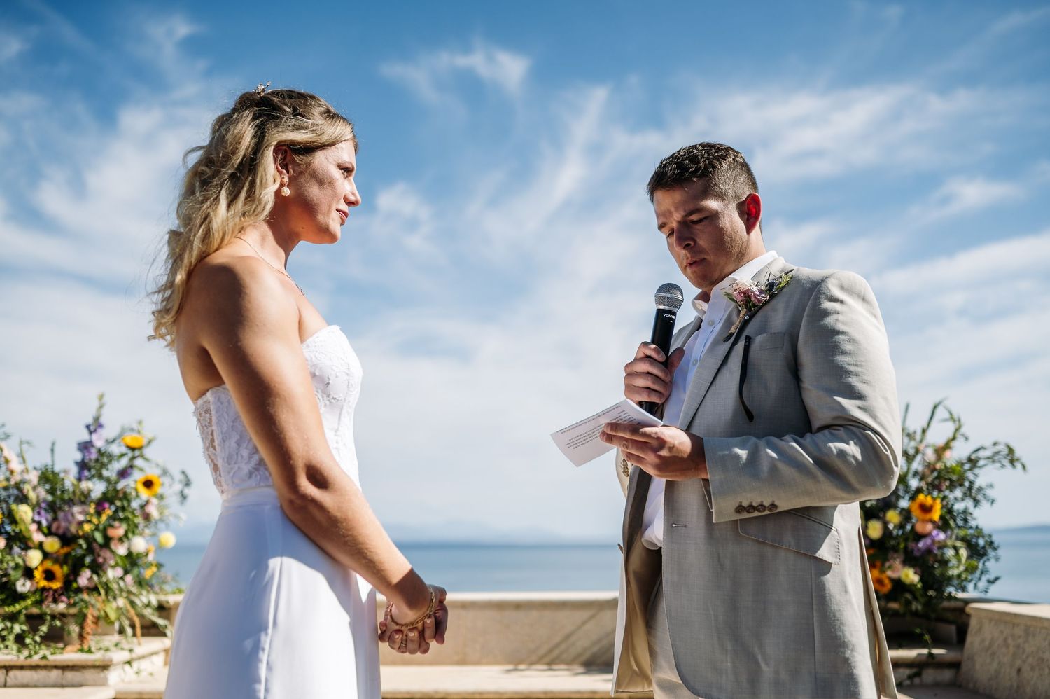 Beachside wedding ceremony with bright blue skies and floral arrangements.