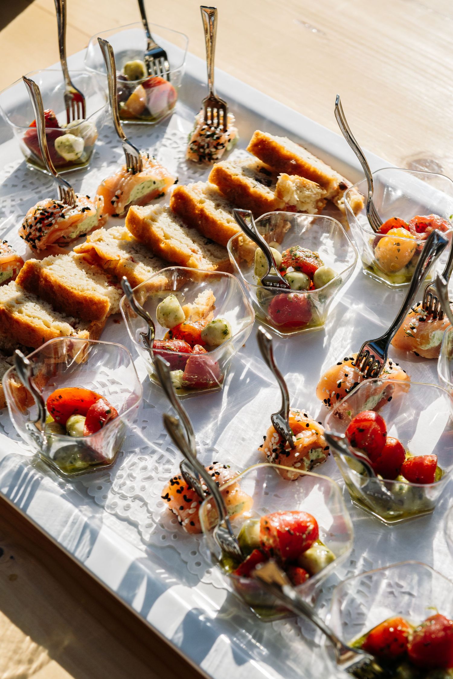 Array of gourmet appetizers served on individual glass plates with decorative garnishes.