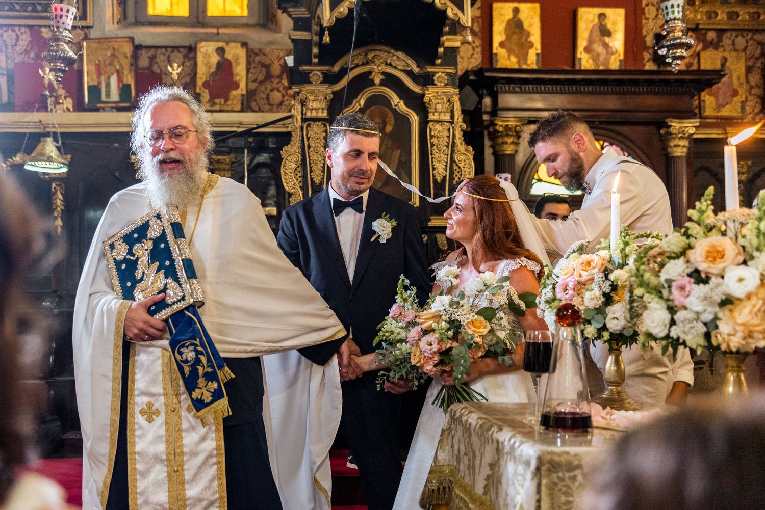Orthodox wedding ceremony with traditional religious icons and decorative elements in the background.