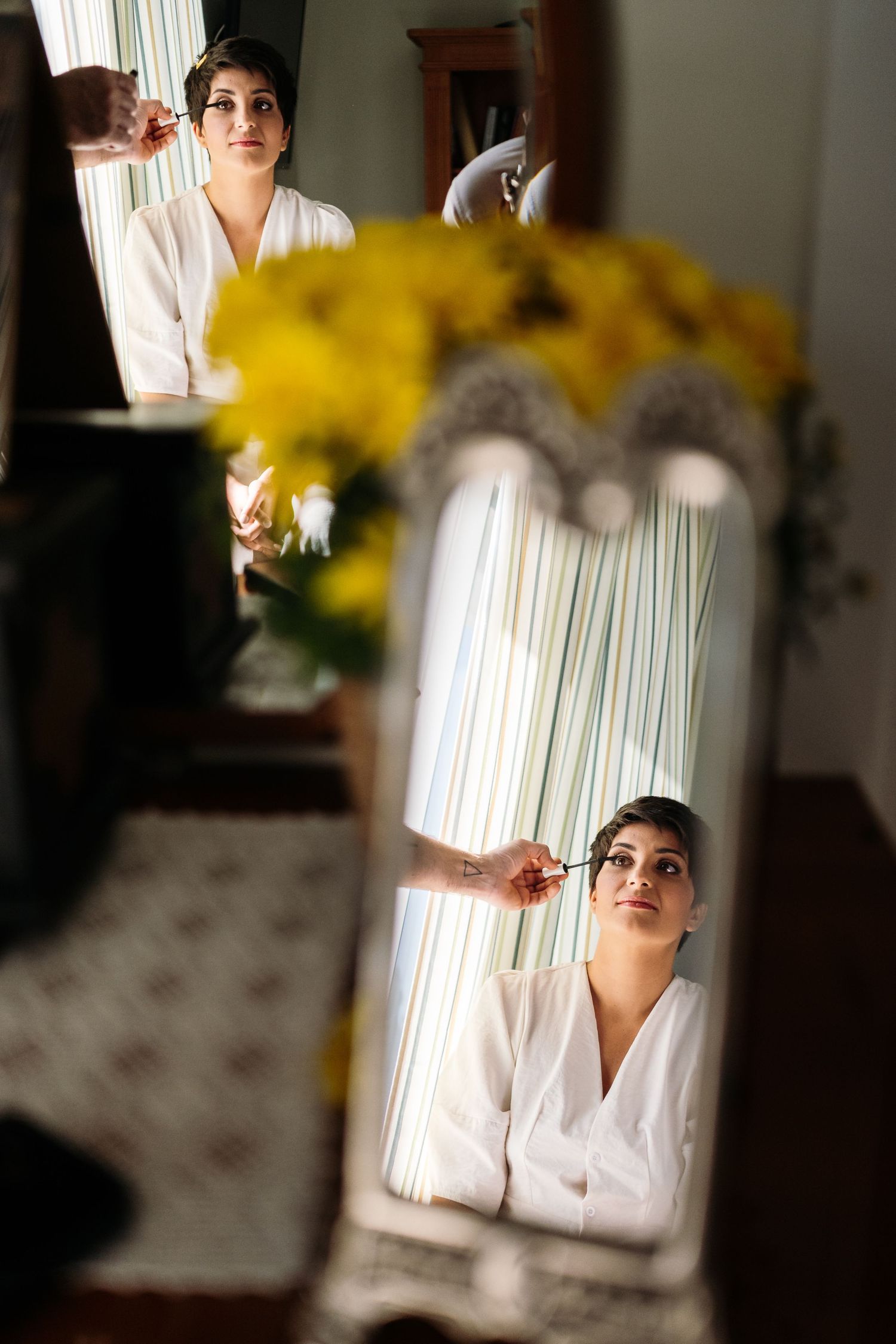 Mirror reflection showing preparation with yellow flowers in foreground.