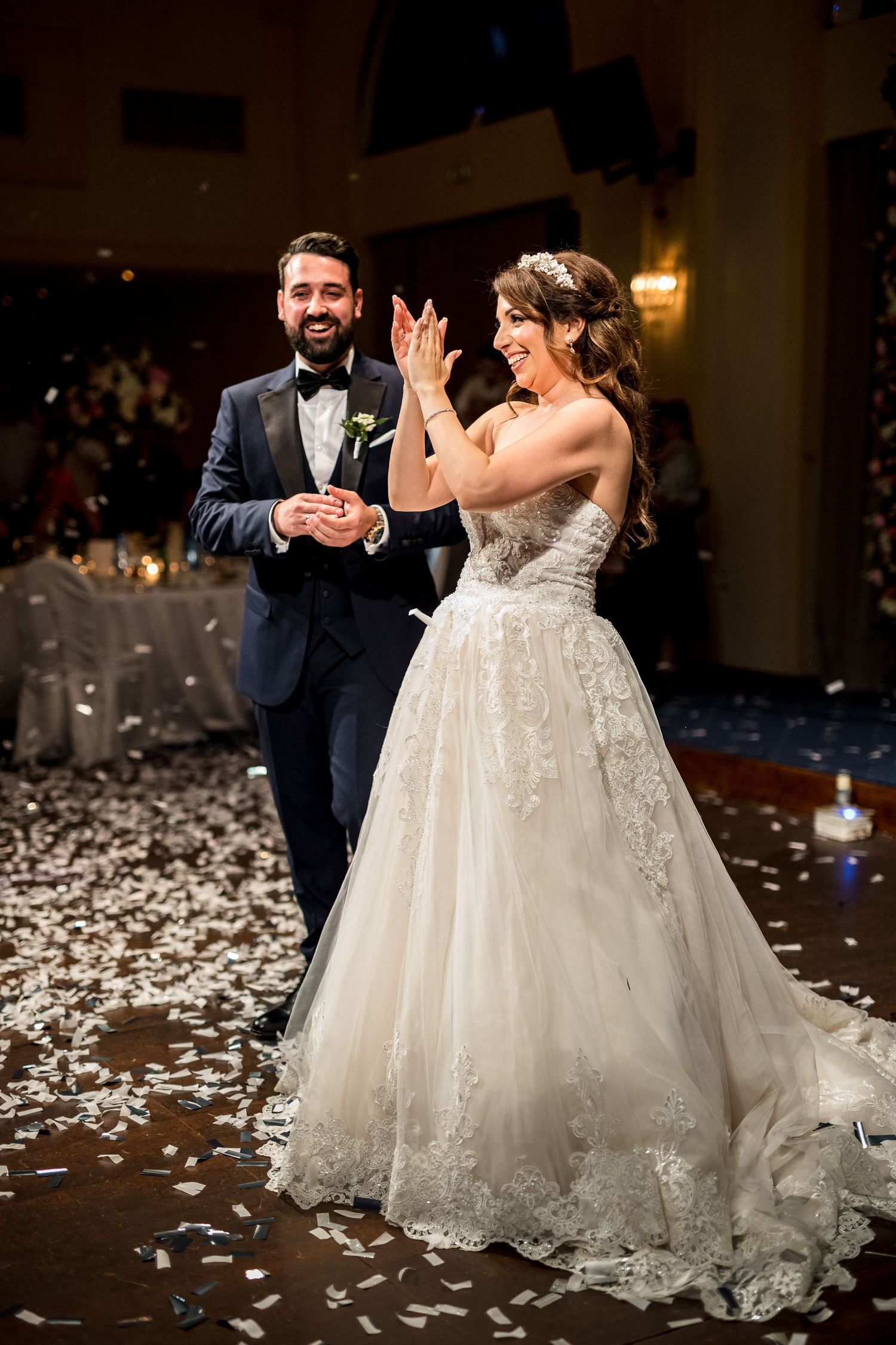 Couple dancing on a confetti-covered floor during their wedding reception celebration.