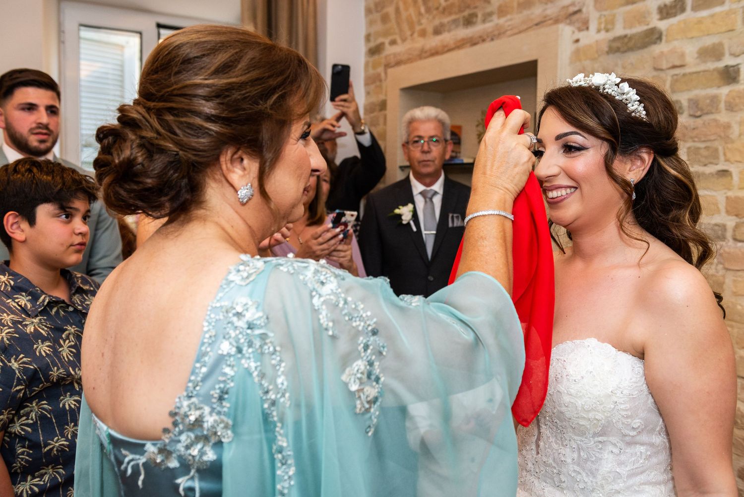 Wedding guests in turquoise dresses mingle during the reception.