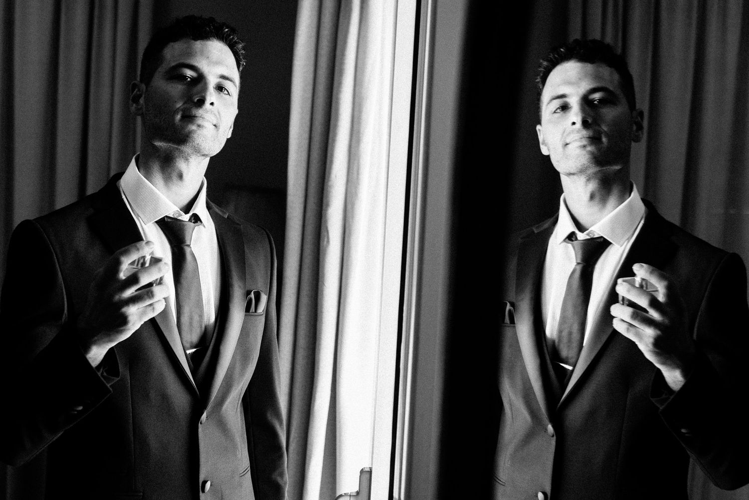 Black and white portraits showing preparation moments with dramatic window lighting.