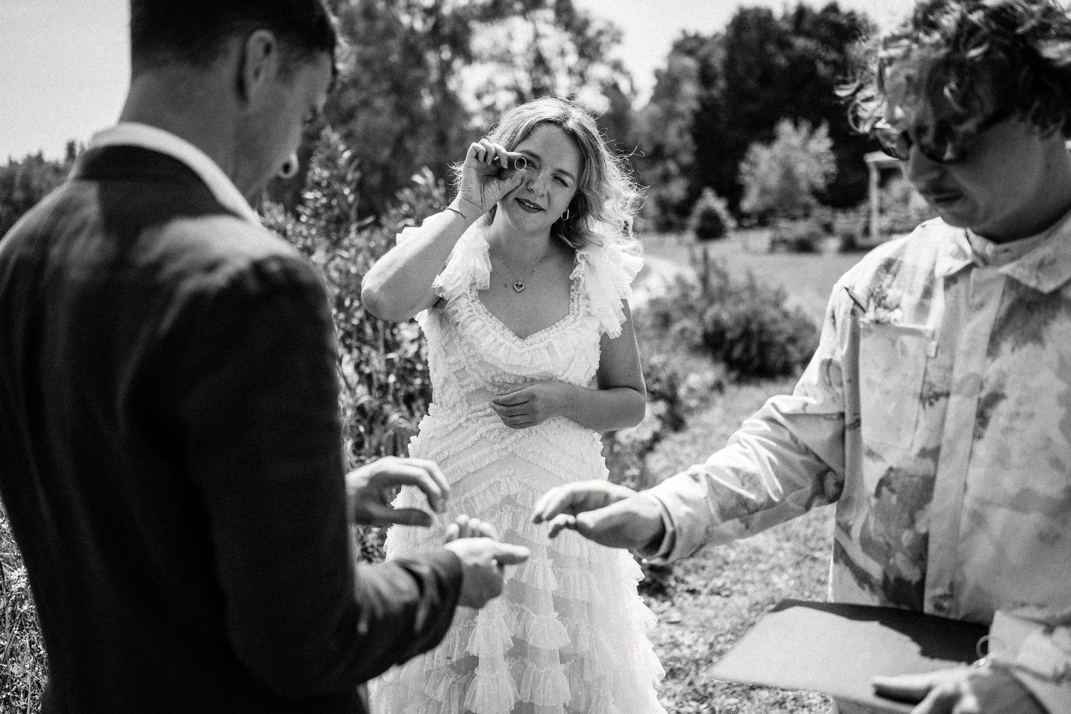 Black and white candid moments captured during an outdoor wedding ceremony.