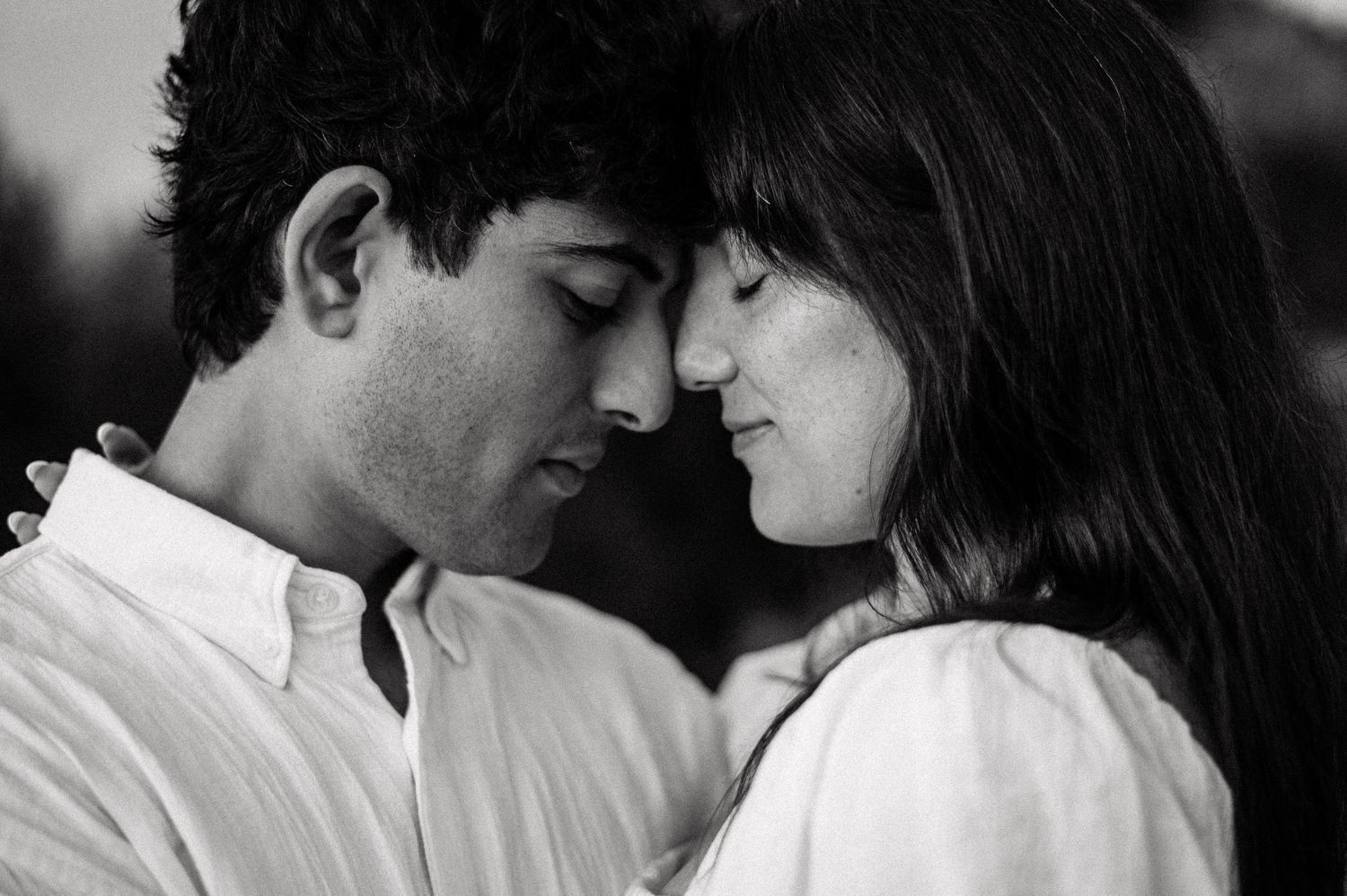 Intimate black and white close-up portrait of a couple in a romantic moment.