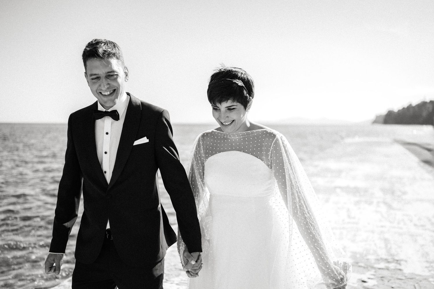 Black and white wedding portraits captured along the oceanfront.