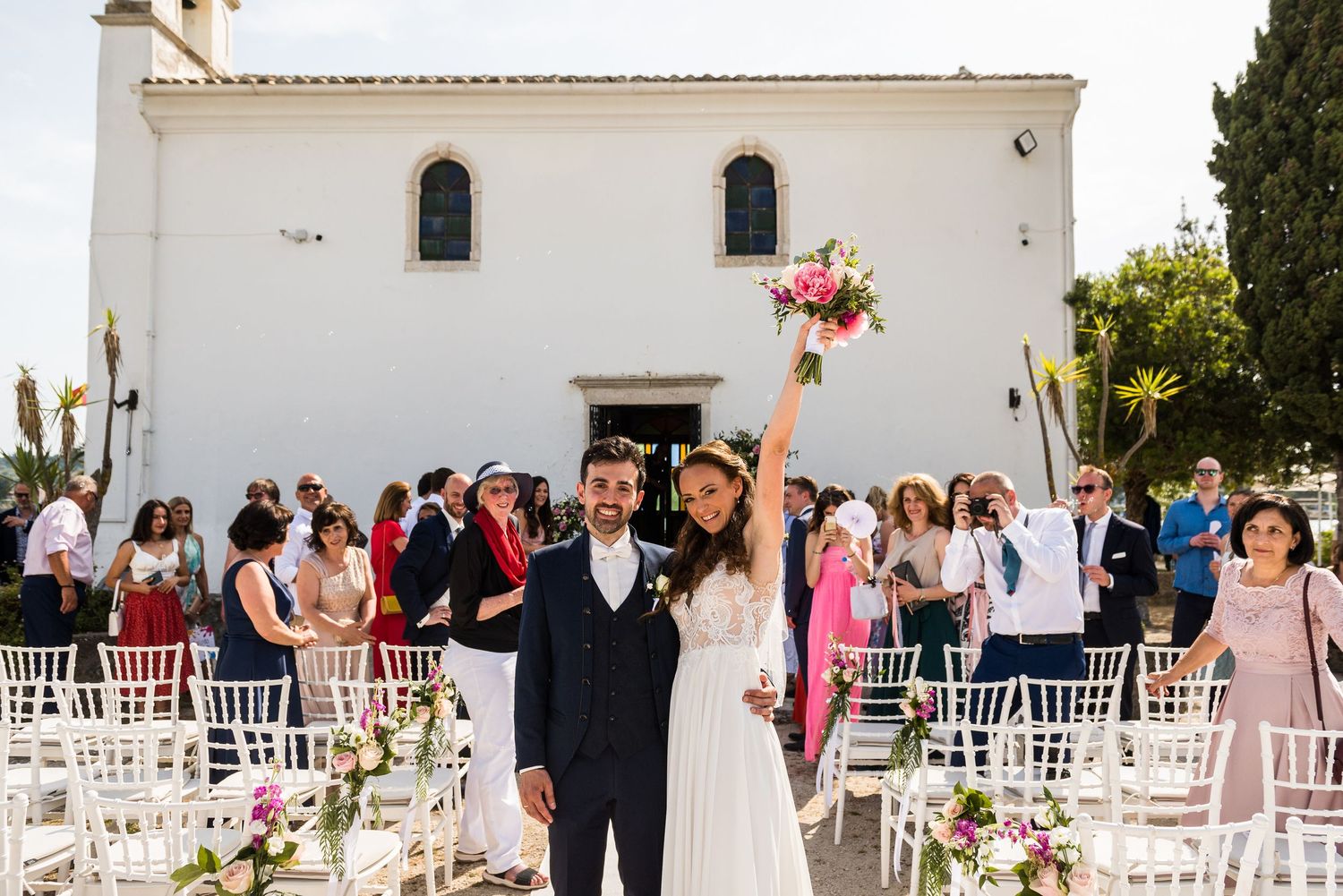 White Mediterranean-style wedding venue with outdoor seating arrangements.