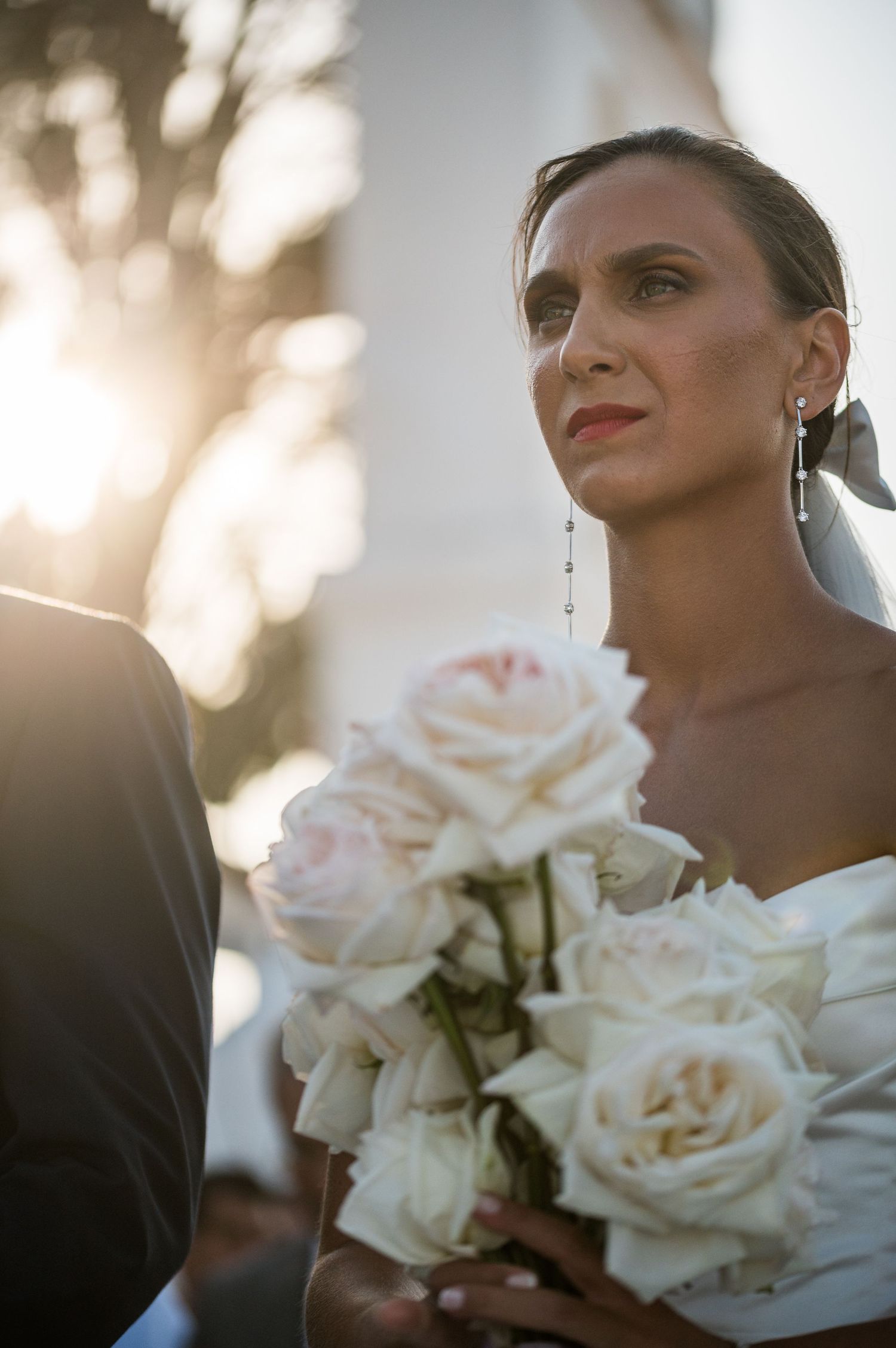 Close-up of white roses bouquet with soft sunlight creating romantic atmosphere.
