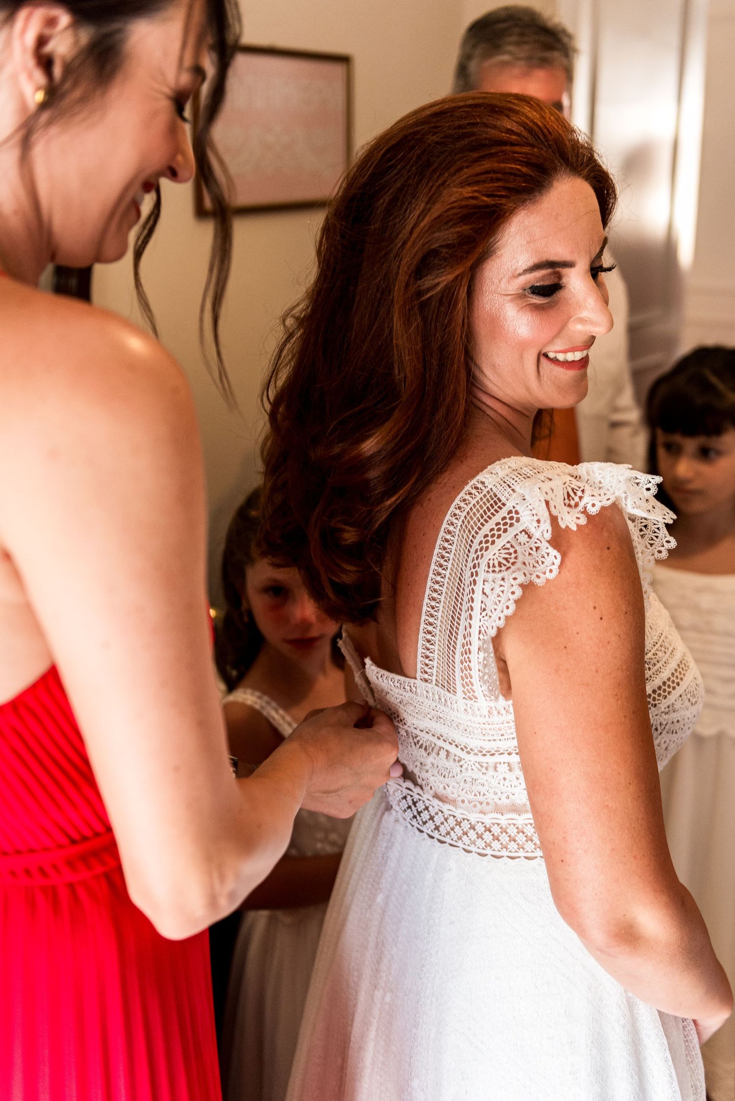 A series of candid shots showing women in white lace and red dresses getting ready.
