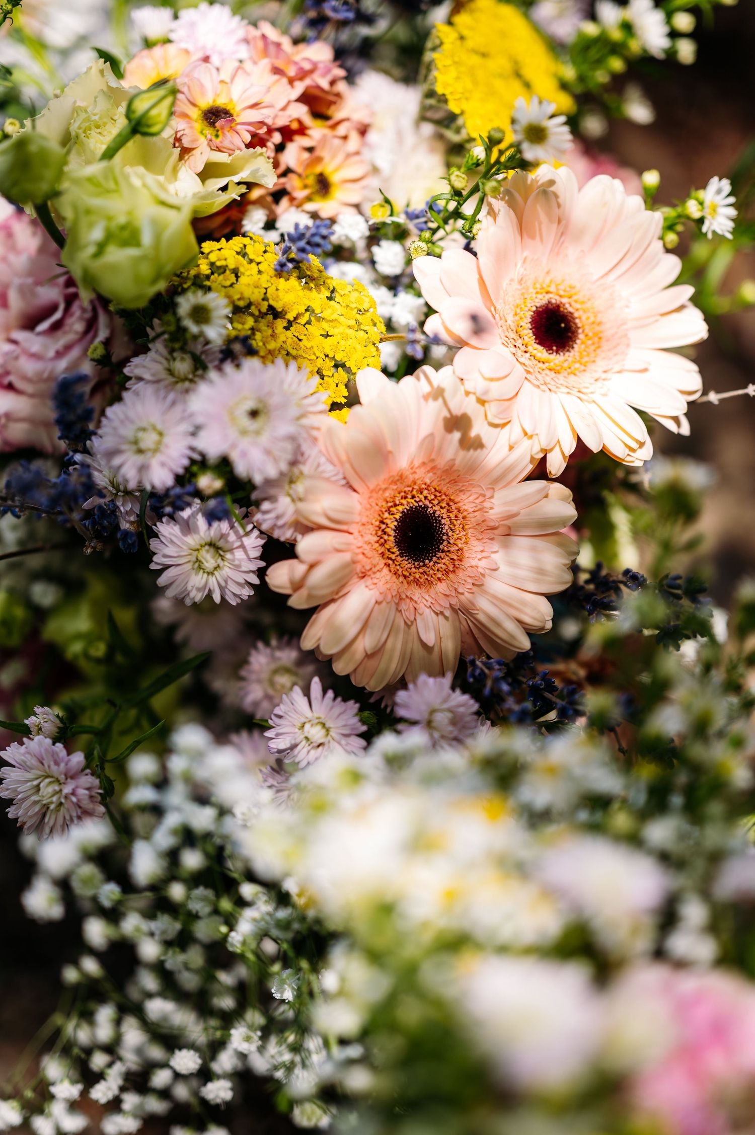 Close-up of delicate pink gerbera daisies and white flowers in a romantic arrangement.