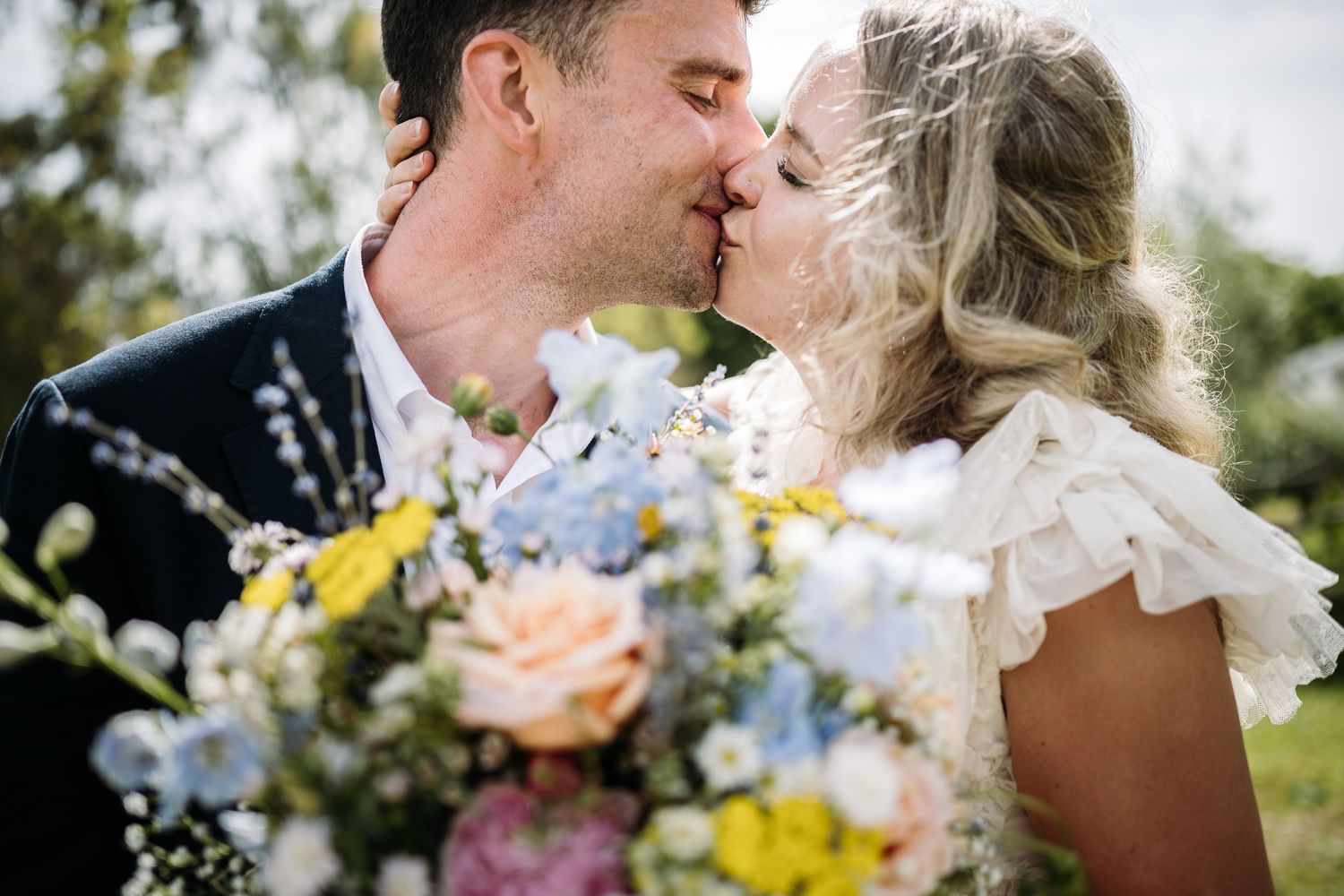 A romantic moment captured during an outdoor wedding celebration.