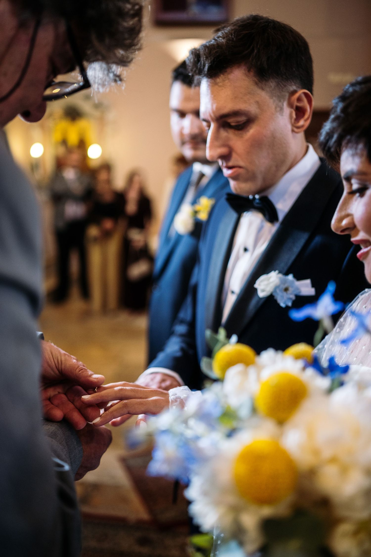 Close-up shots of wedding party members with yellow and white floral arrangements.