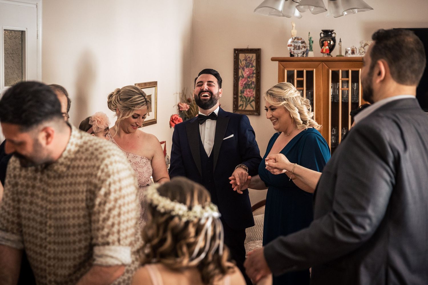 Wedding guests gather for photos in a room with brick walls and elegant decor.