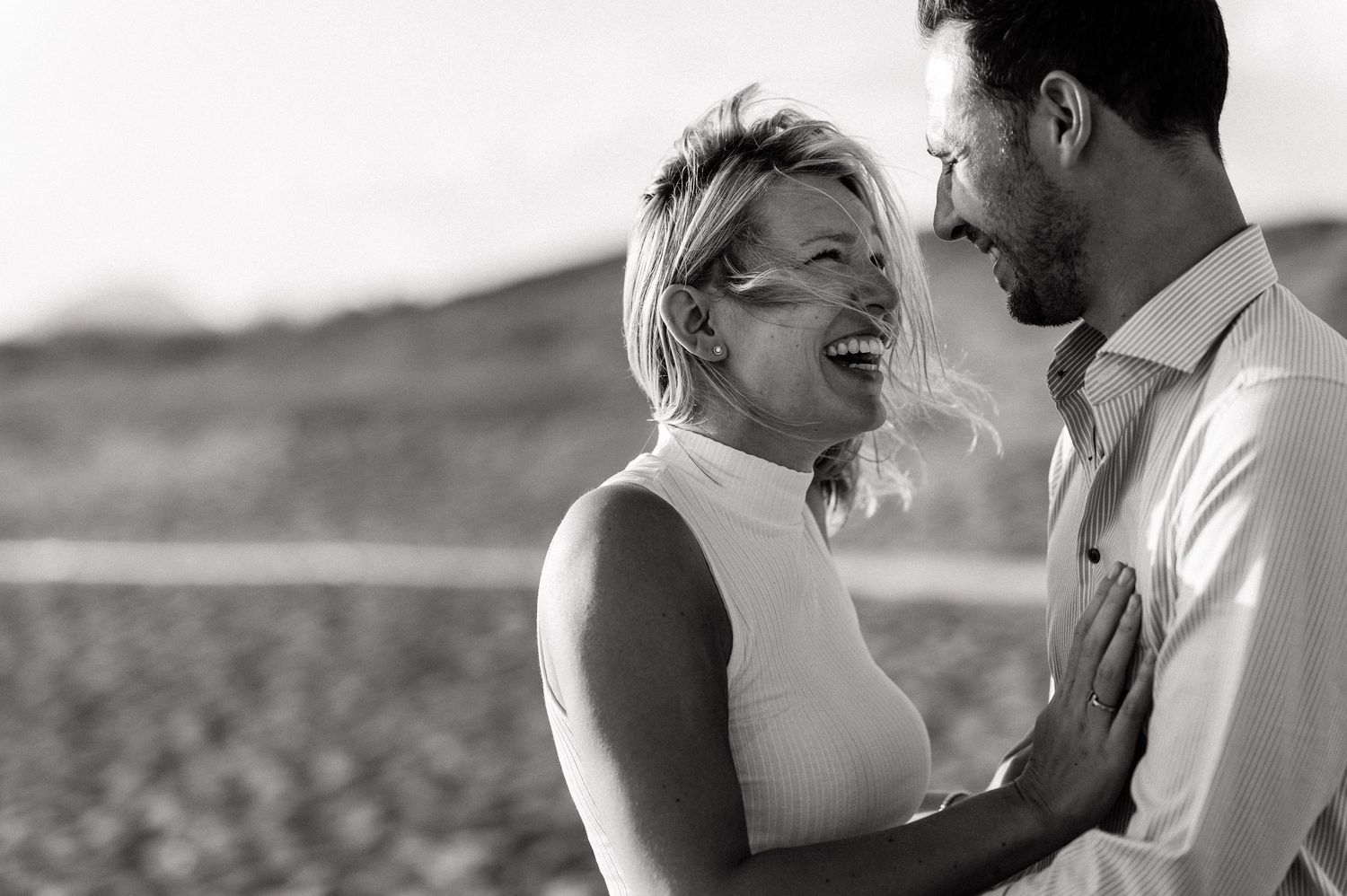 Black and white capture of pure joy and laughter on a beach.
