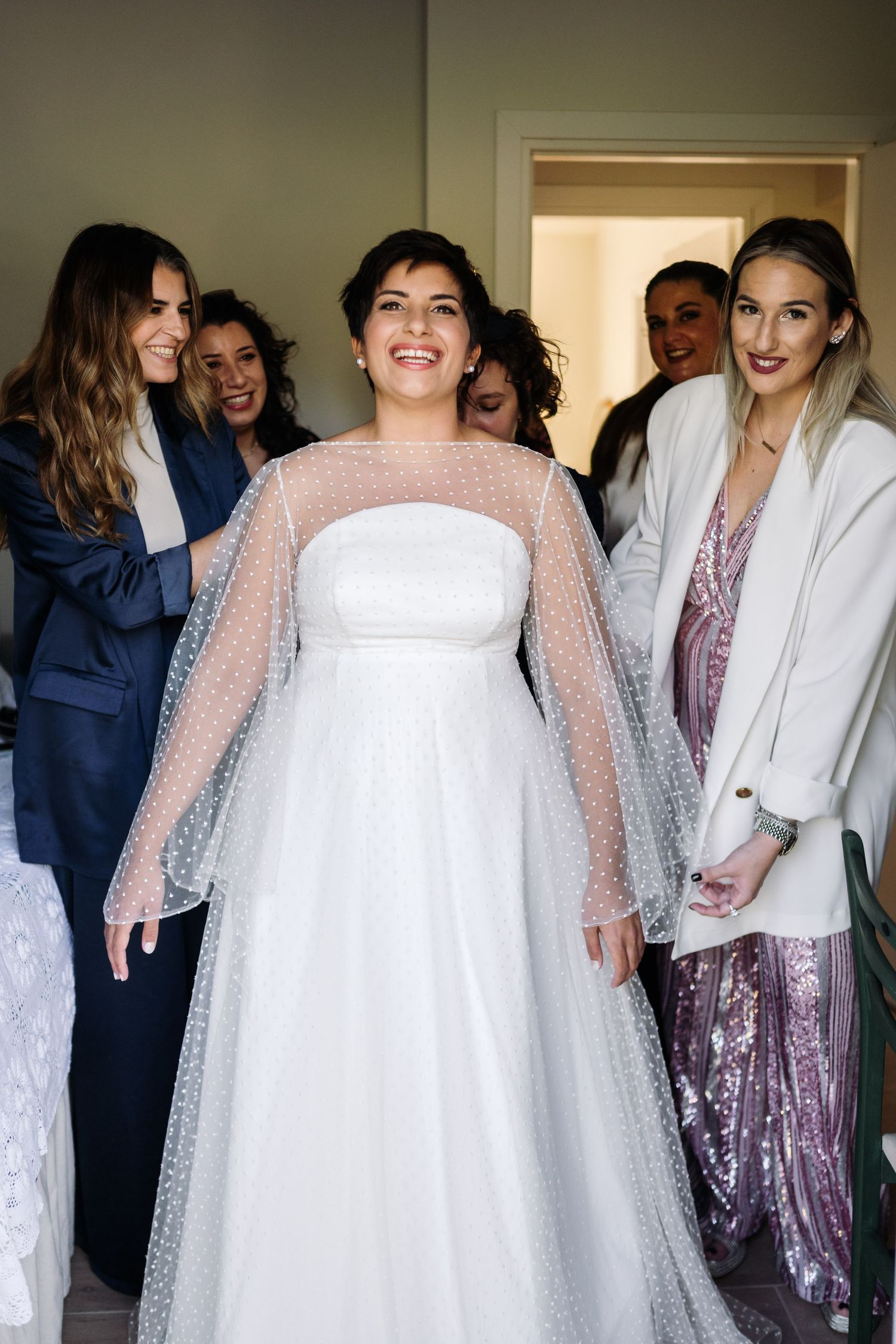 Bridal party in white and sparkly dresses preparing for the ceremony.
