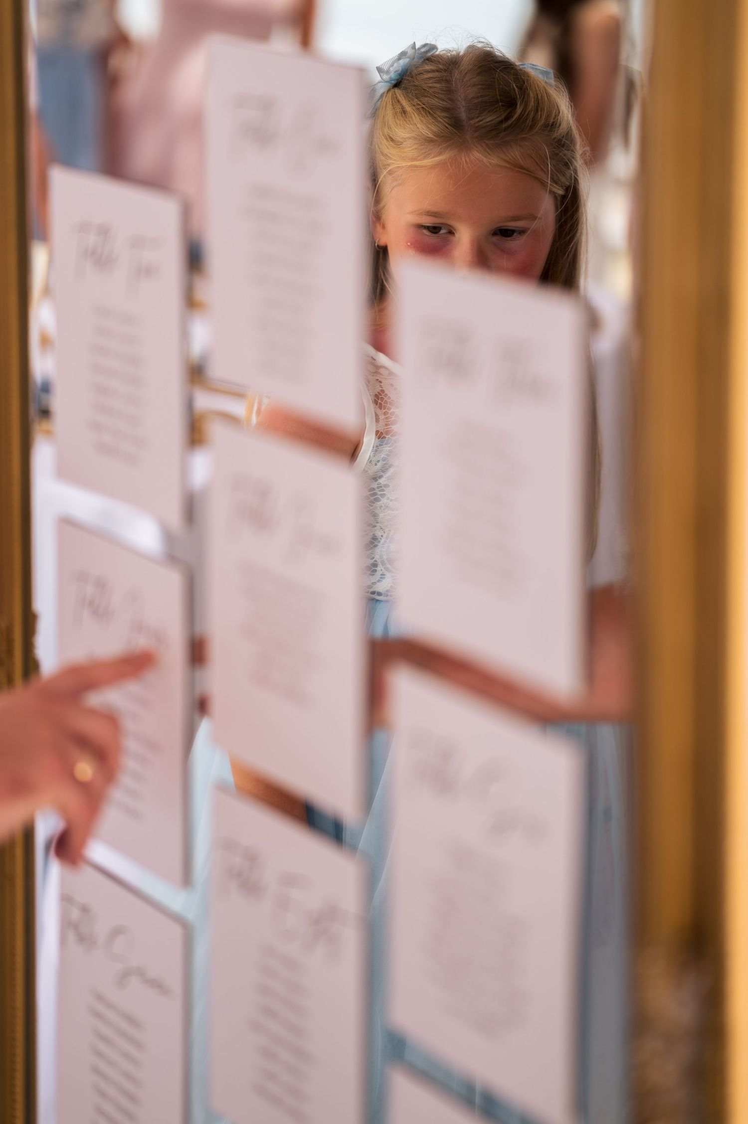 Wedding seating chart display with paper cards arranged on a wall.