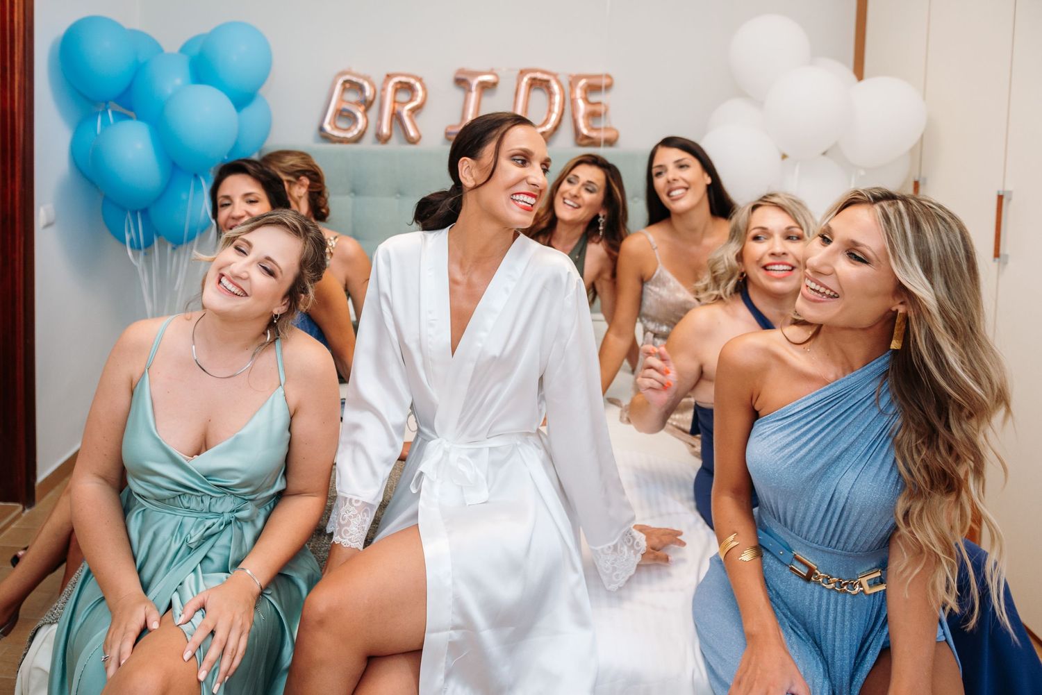Pre-wedding celebration with bridesmaids in blue dresses and white decor.
