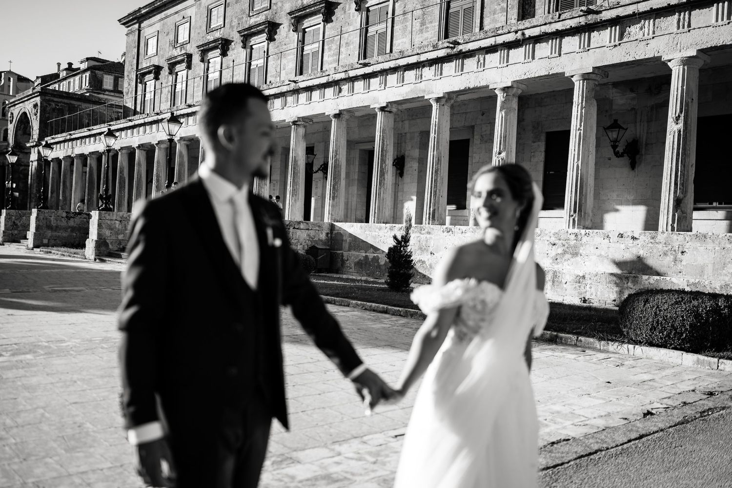 Black and white photo of wedding couple dancing in architectural setting with dramatic perspective.