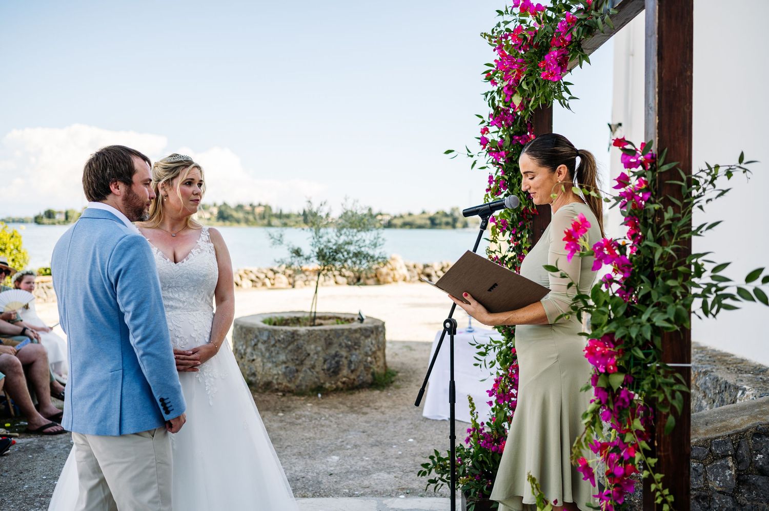 An intimate wedding ceremony moment framed by bright pink bougainvillea flowers.